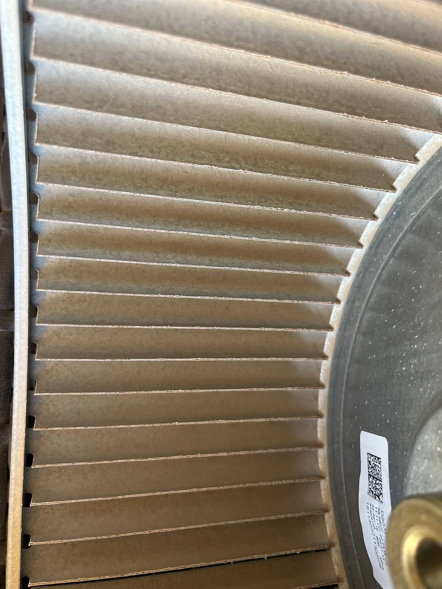 Close-up of an HVAC blower wheel showing dust accumulation on the fins before cleaning.