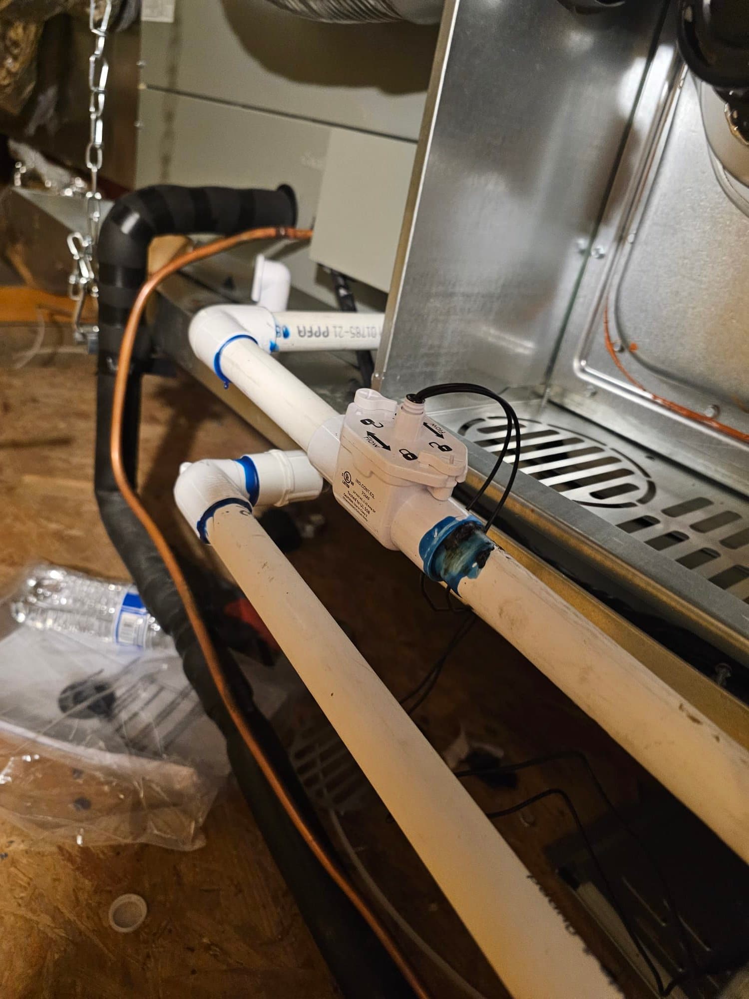 Condensate drain assembly with float safety switch wired in, PVC piping glued and routed beside the air handler in the attic.