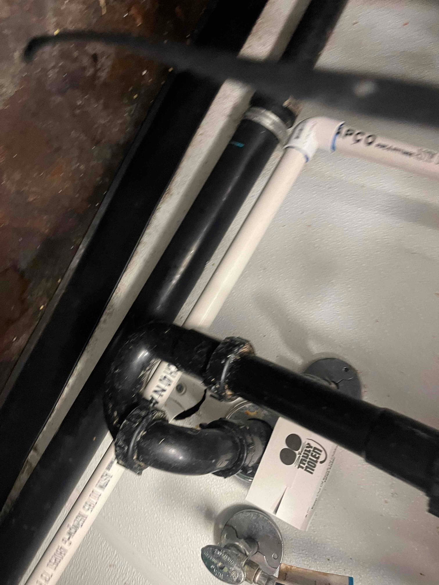 Condensate drain assembly with PVC and black trap piping installed near the indoor unit, showing clean routing and fittings.