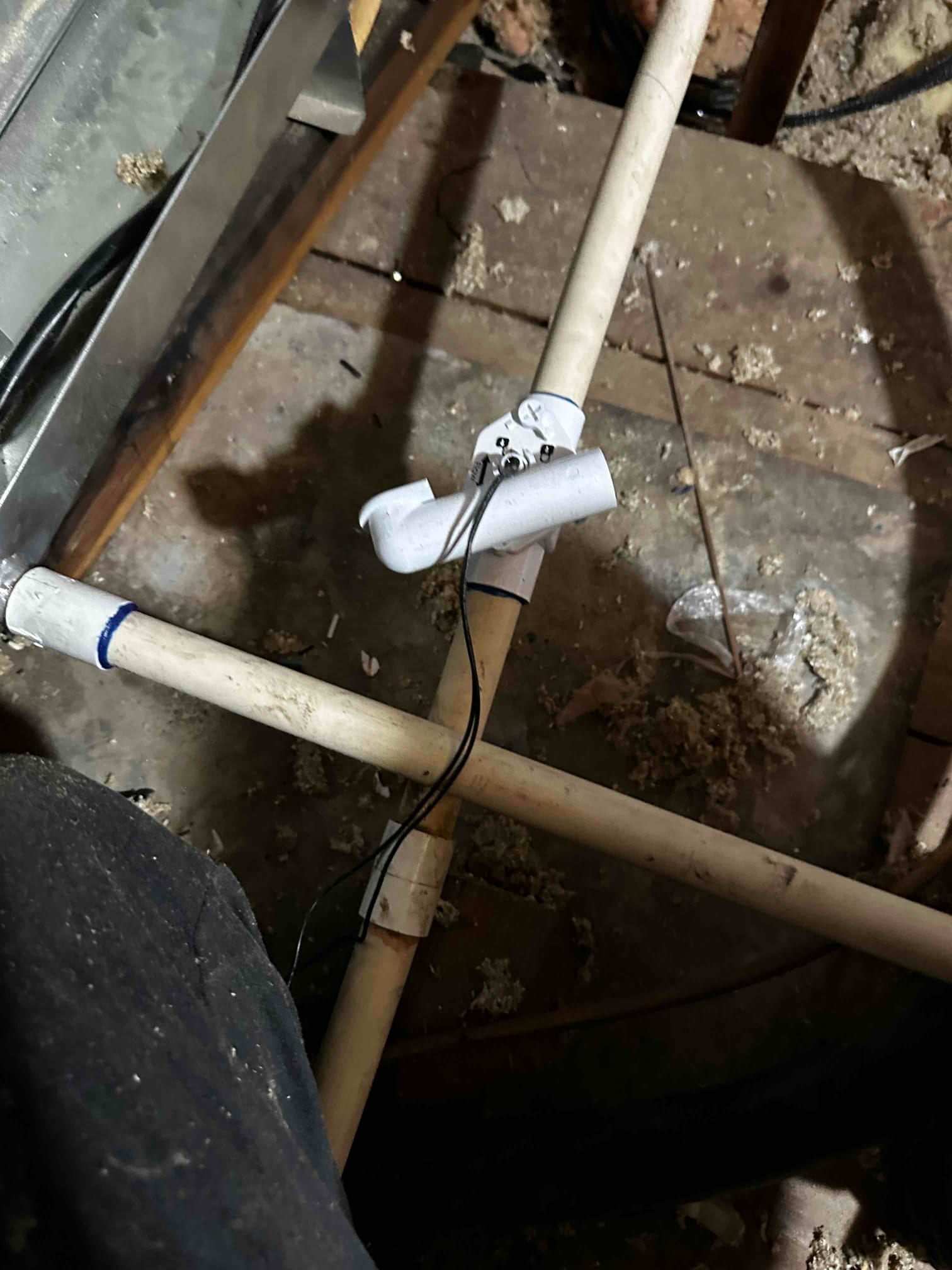 Condensate drain piping in the attic with an inline float safety switch installed and wired to the air handler.