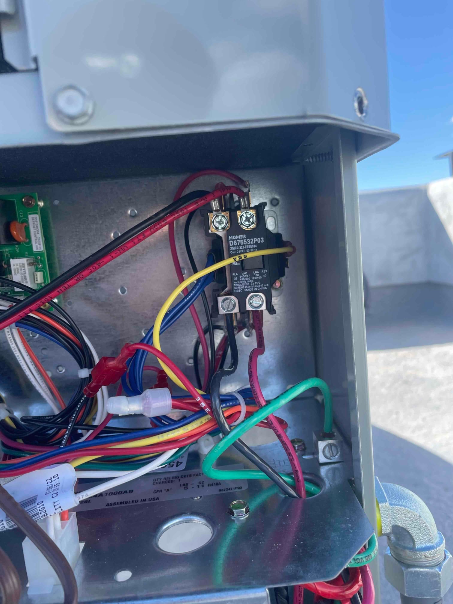 Condenser control compartment with contactor, ground connection, and organized low- and high-voltage wiring secured inside the unit.