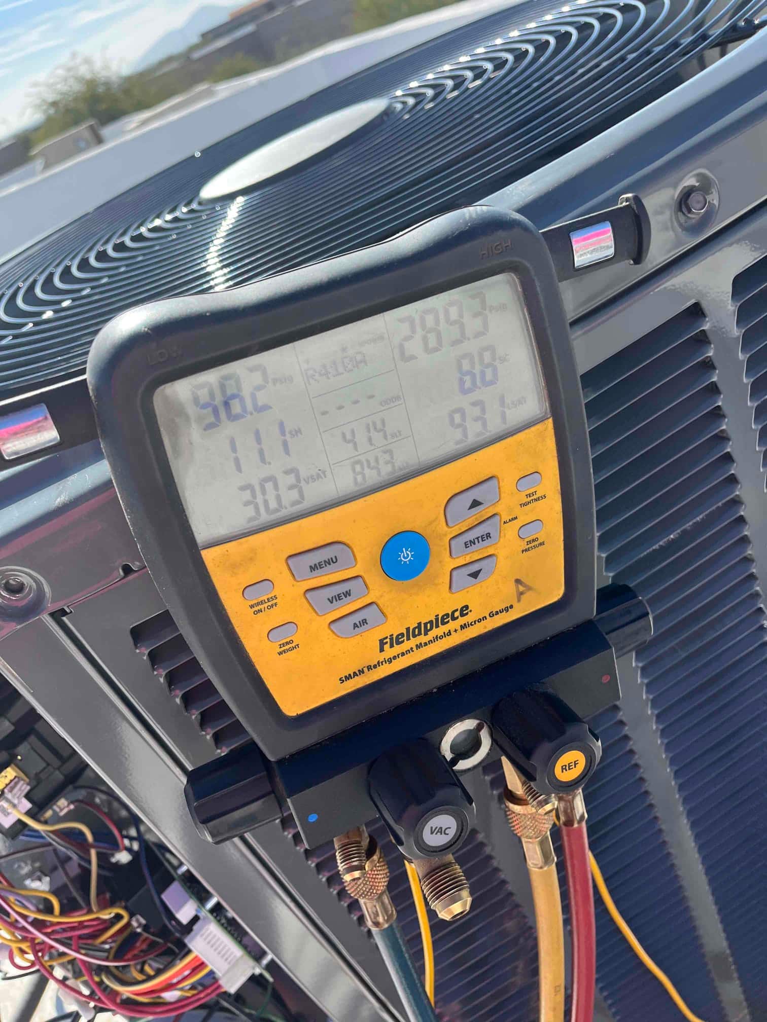 Digital manifold attached to the outdoor unit displays operating pressures and temperatures during system commissioning.