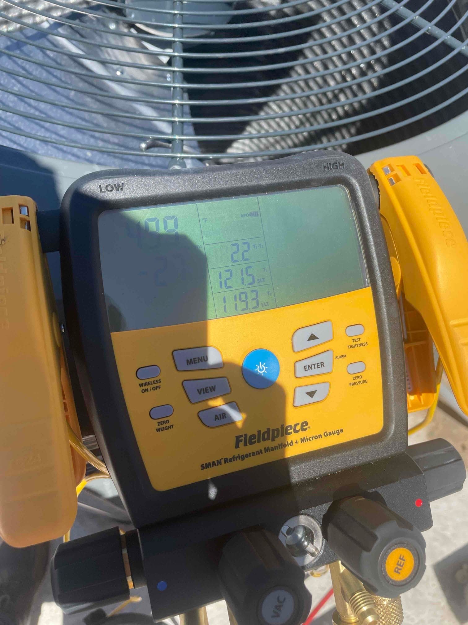 Digital manifold connected at the outdoor unit displays operating pressures and temperatures during system commissioning.