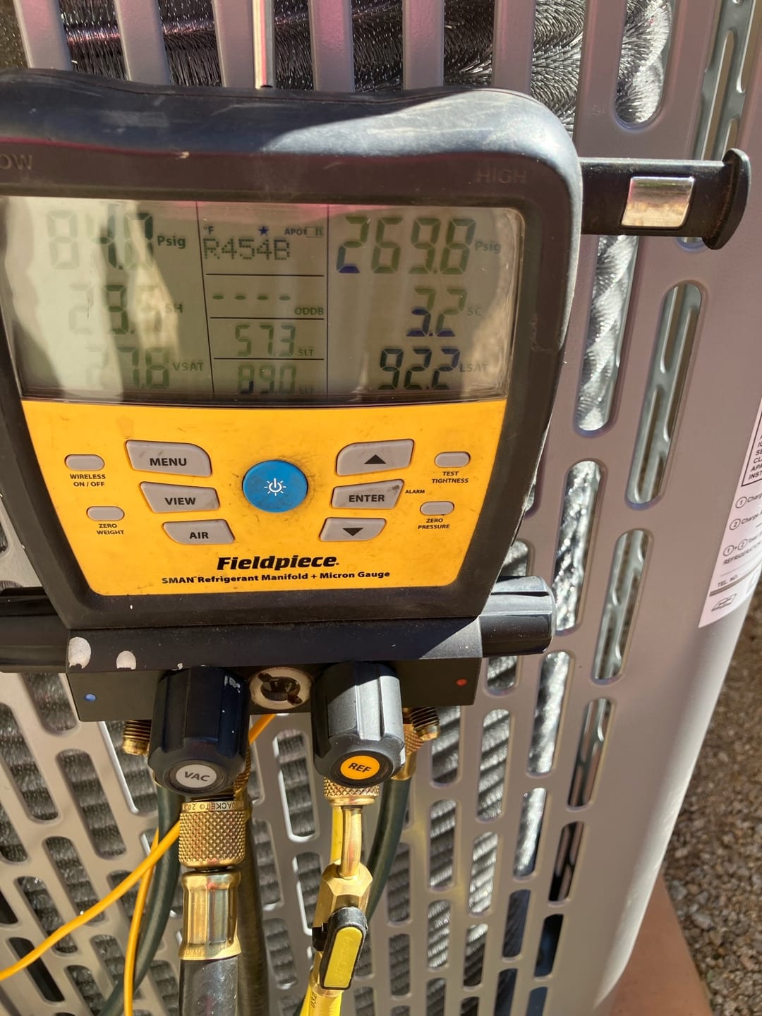 Digital manifold connected at the outdoor unit shows operating pressures while charging and commissioning the new system.