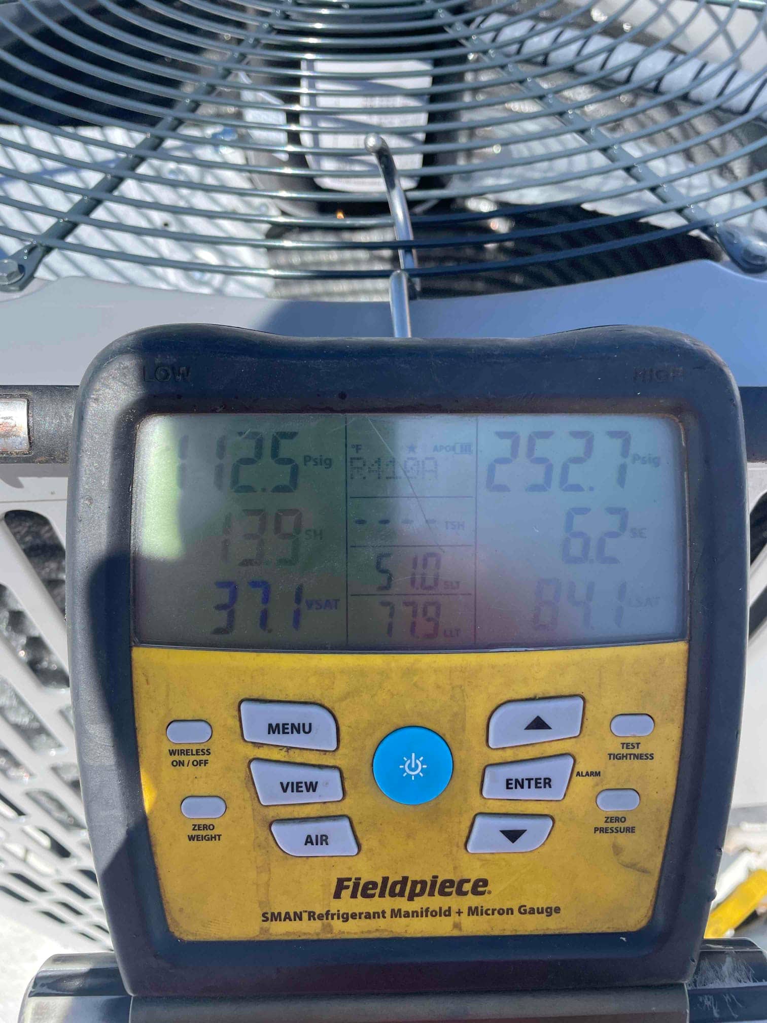 Digital manifold connected to the outdoor unit shows operating pressures and temperatures during refrigerant commissioning of the new system.