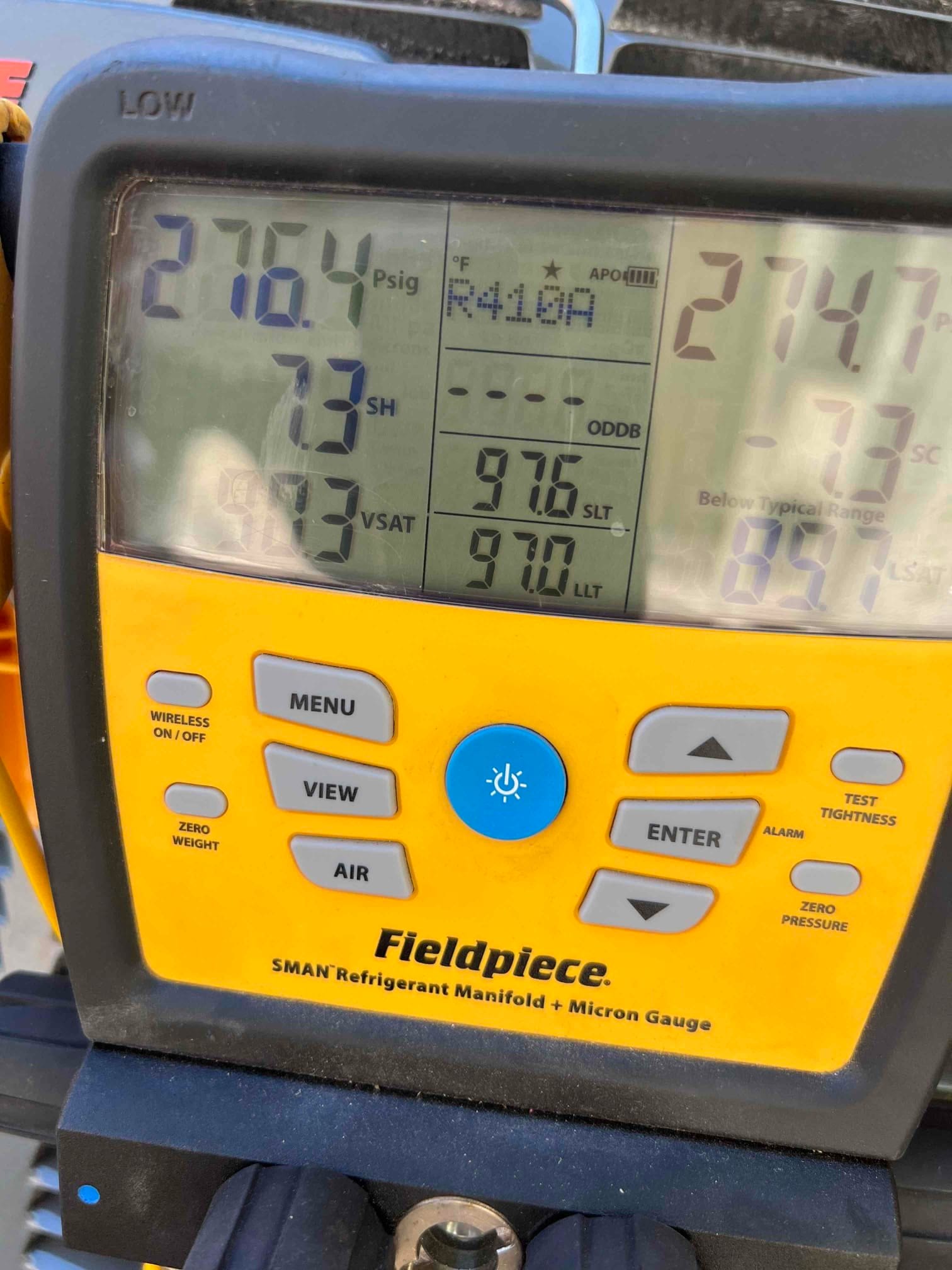 Digital manifold displays operating pressures with R-410A selected, showing 276 PSIG on the low side and 275 PSIG on the high side.