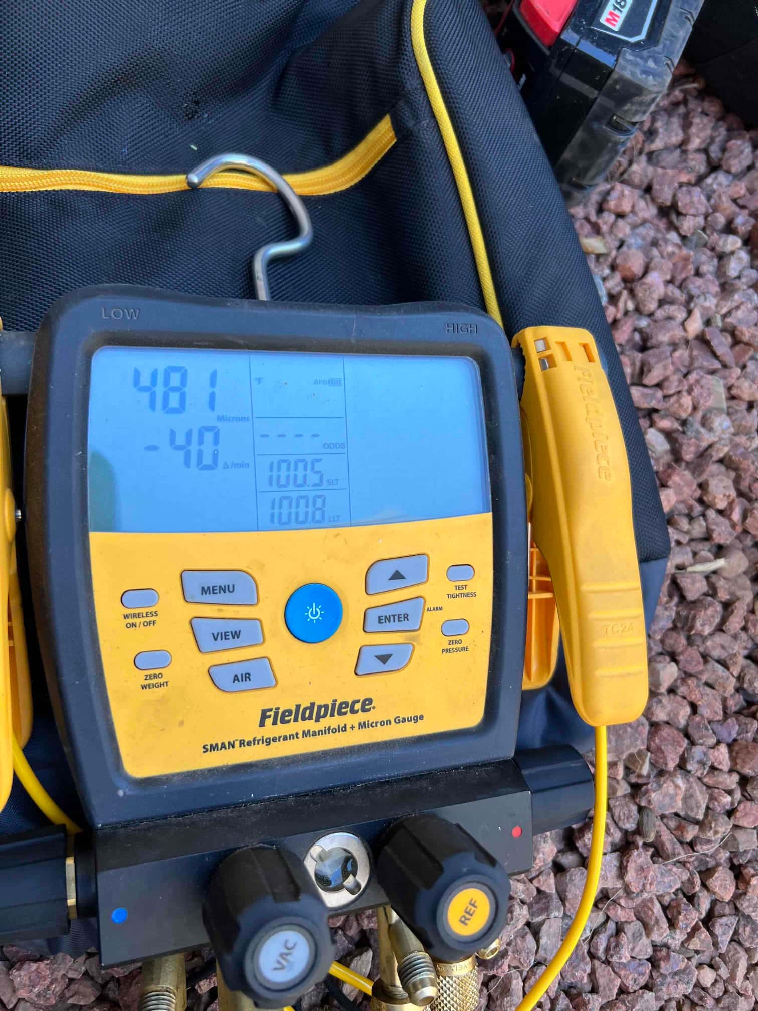 Digital manifold micron gauge displays 481 microns during evacuation, documenting a deep vacuum before releasing refrigerant.