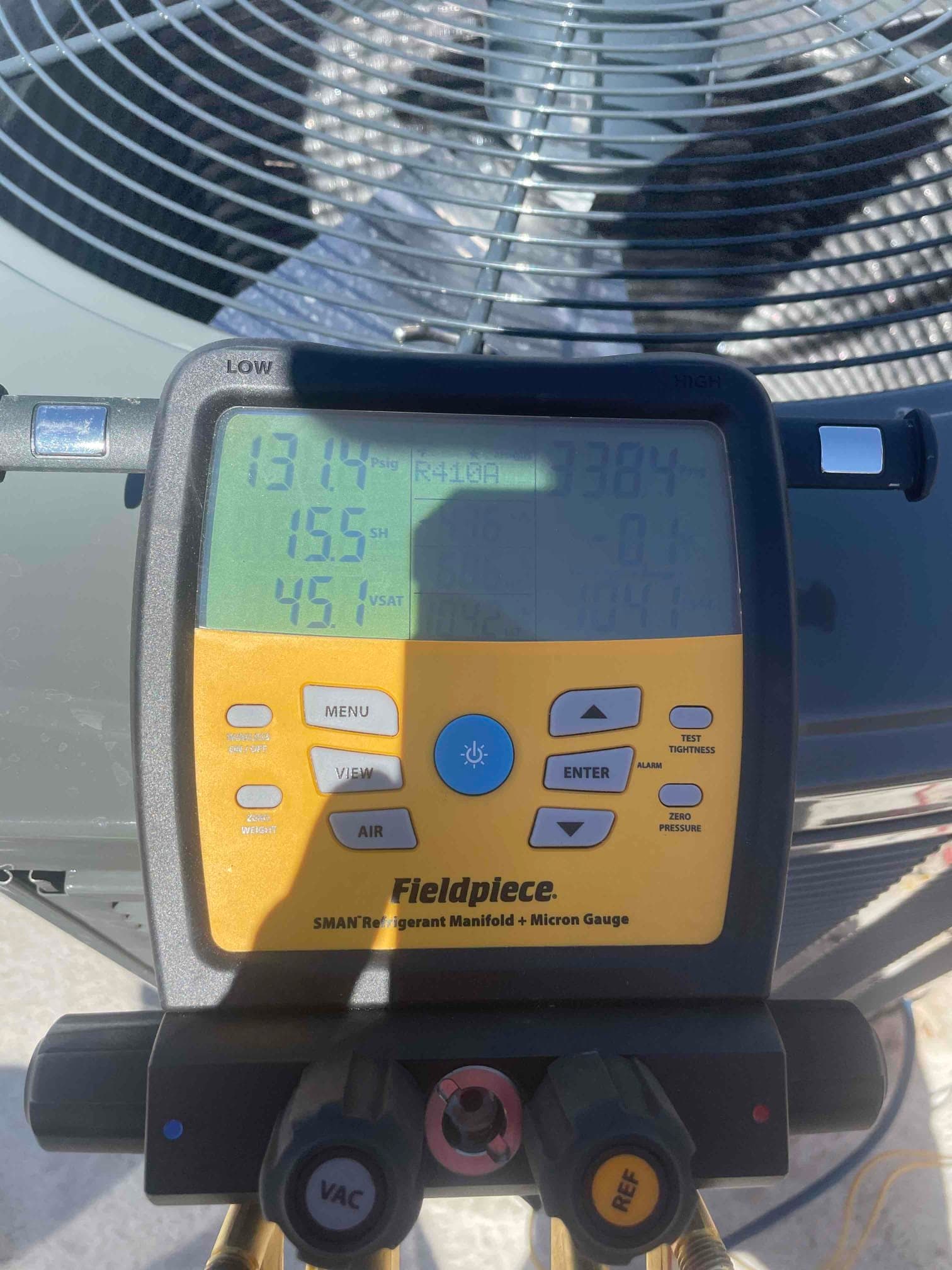 Digital manifold on outdoor unit displays operating pressures with R-410A selected during system commissioning.