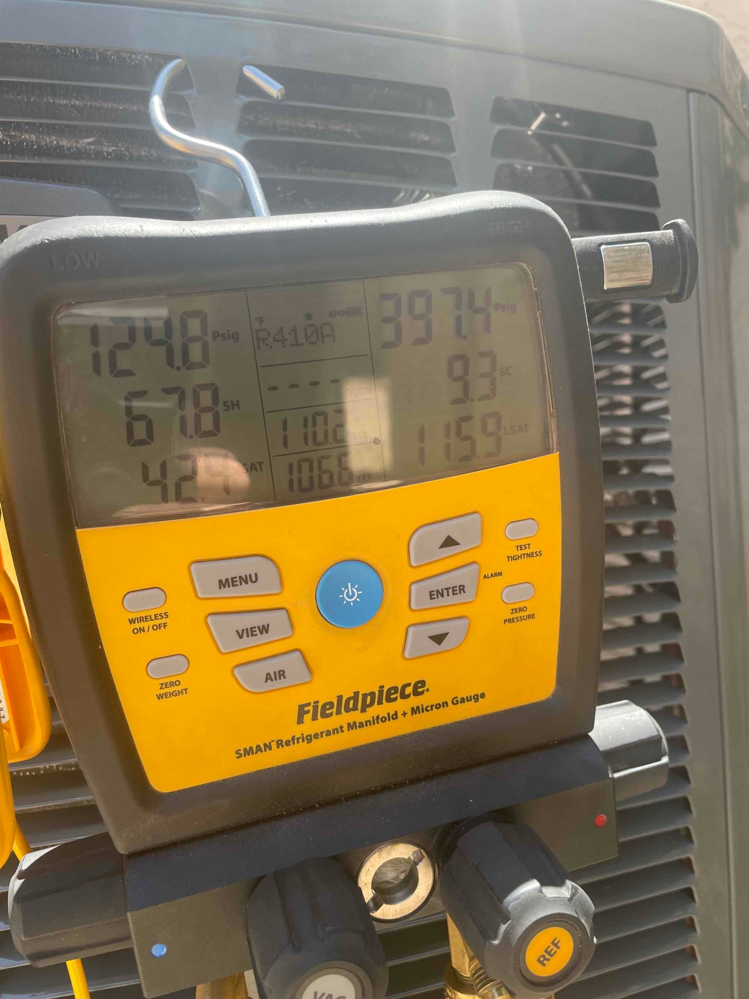Digital manifold on the outdoor unit shows operating pressures with R-410A selected, documenting system refrigerant commissioning measurements.