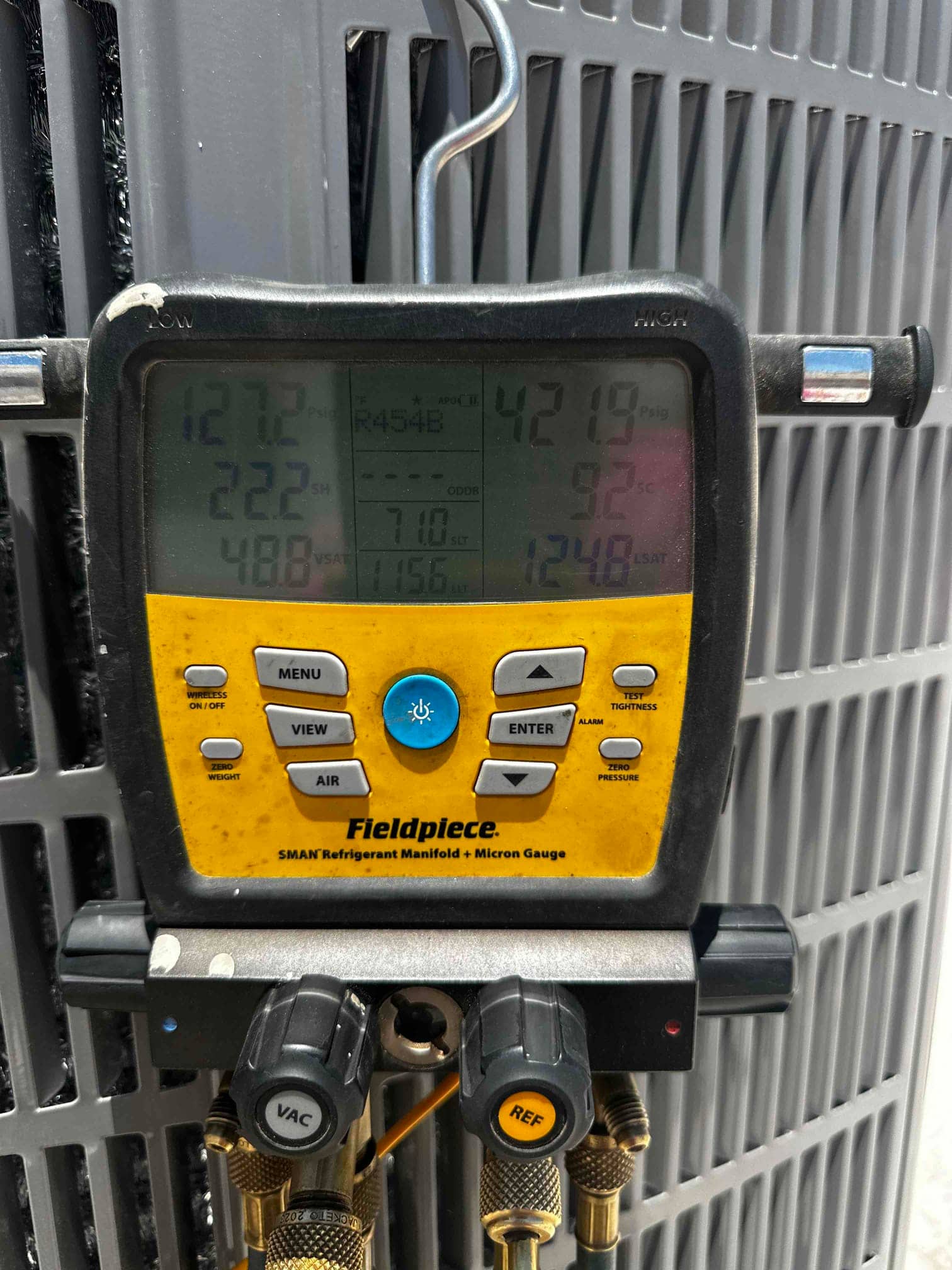 Digital manifold on the outdoor unit shows operating pressures and temperatures during system startup and charge verification.