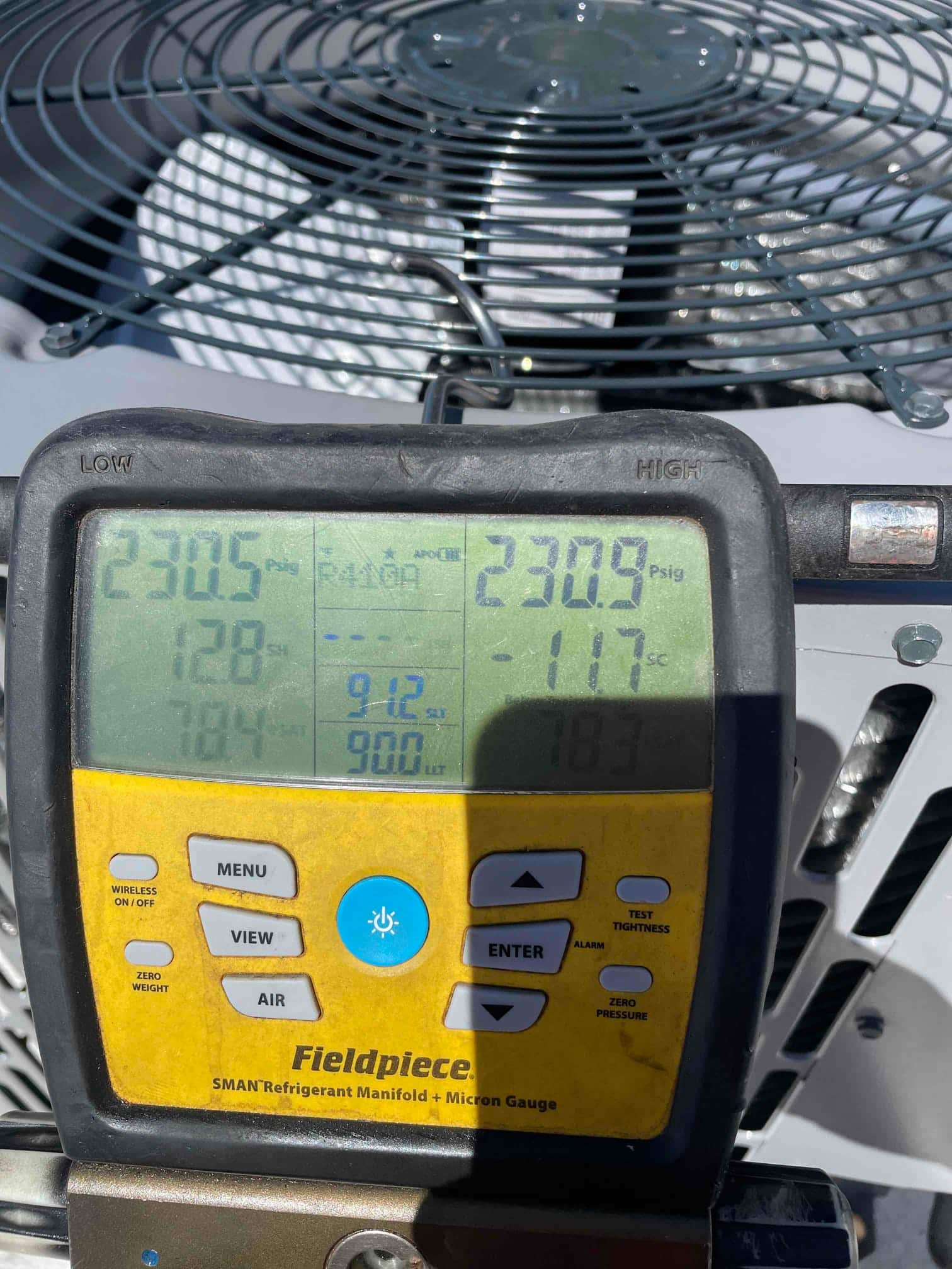 Digital manifold shows both high and low sides holding around 231 PSI during a nitrogen pressure test on the outdoor unit.