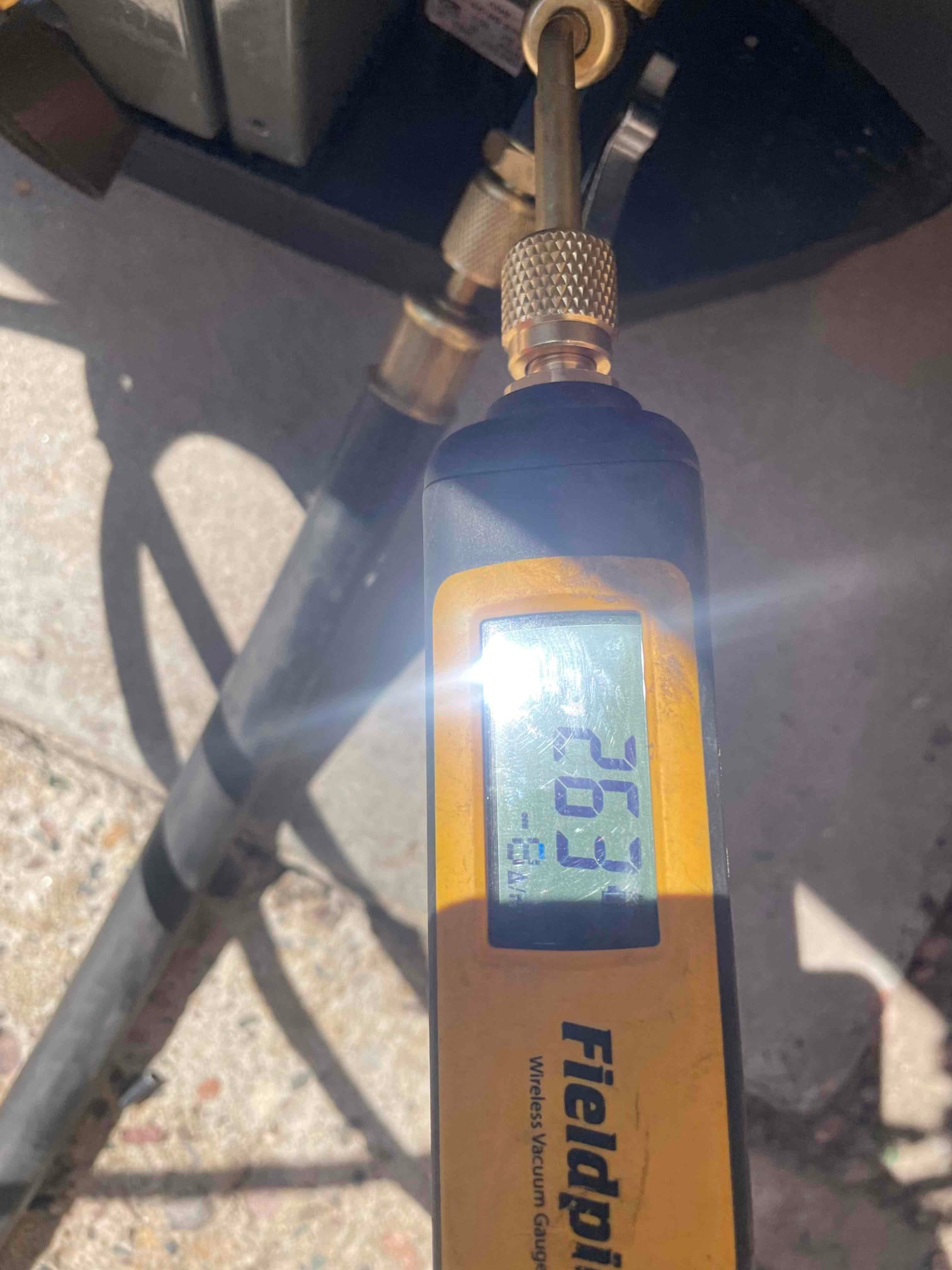 Digital micron gauge connected at the service port reads 263 microns, confirming a deep vacuum before releasing refrigerant.