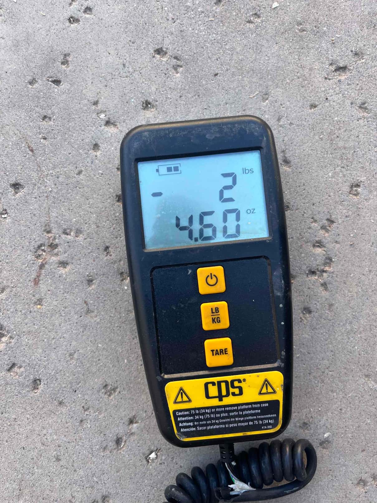 Digital refrigerant scale display shows 2 pounds 4.60 ounces during charging work on the installation.