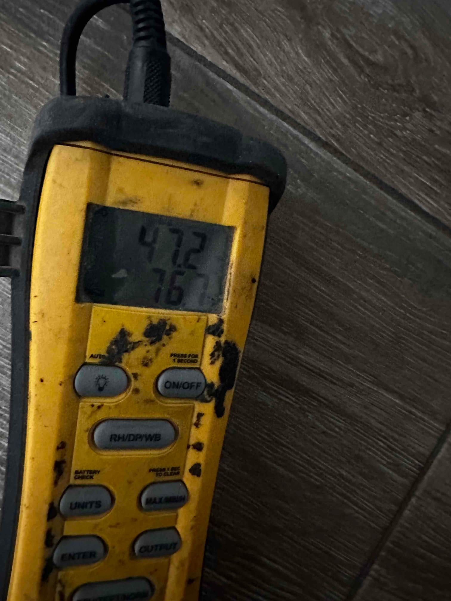 Digital thermometer displays 47.2 degrees, documenting supply air temperature during system checkout.