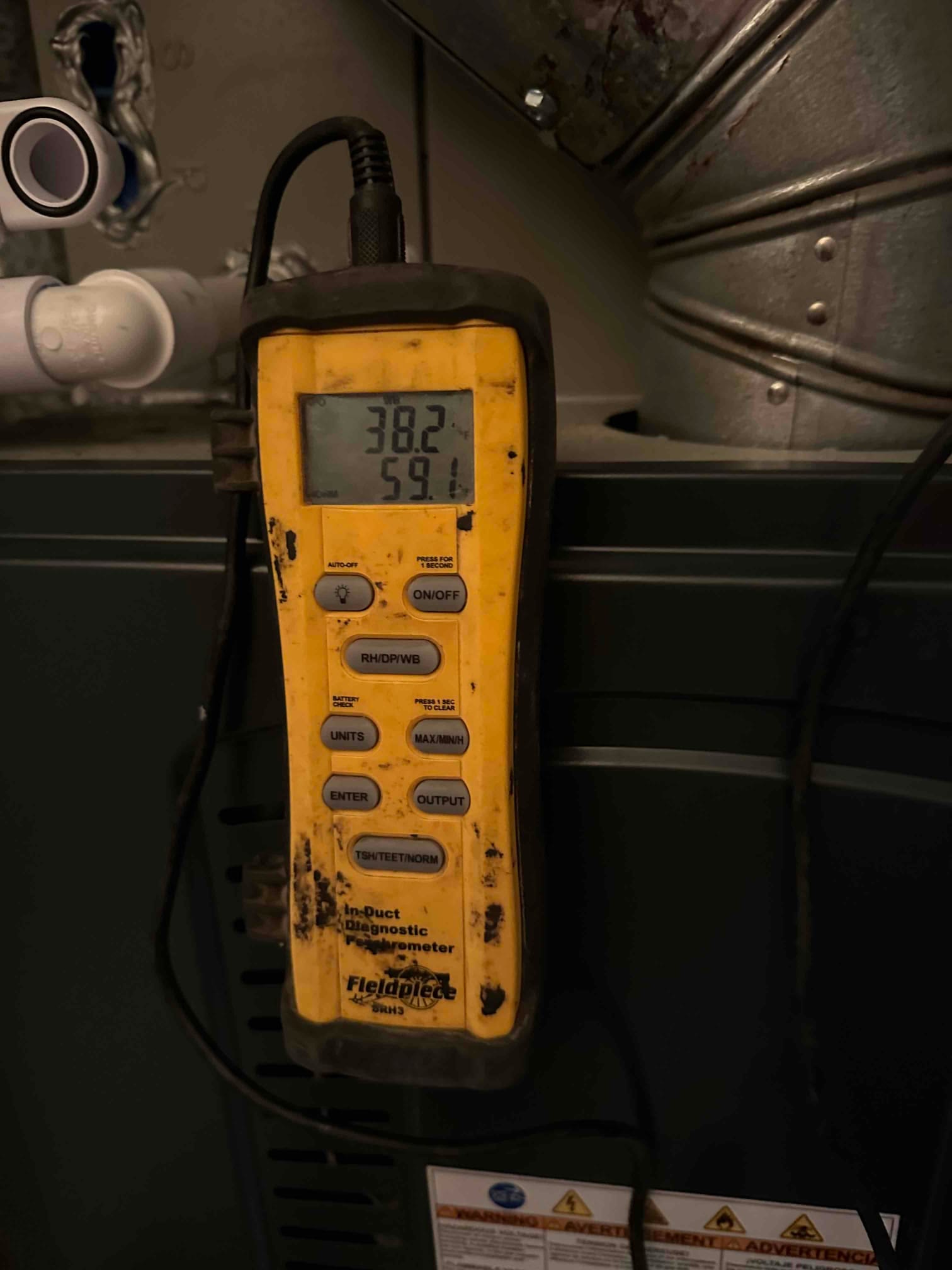 Digital thermometer on the furnace shows 59.1°F air temperature during supply air measurement at the plenum.