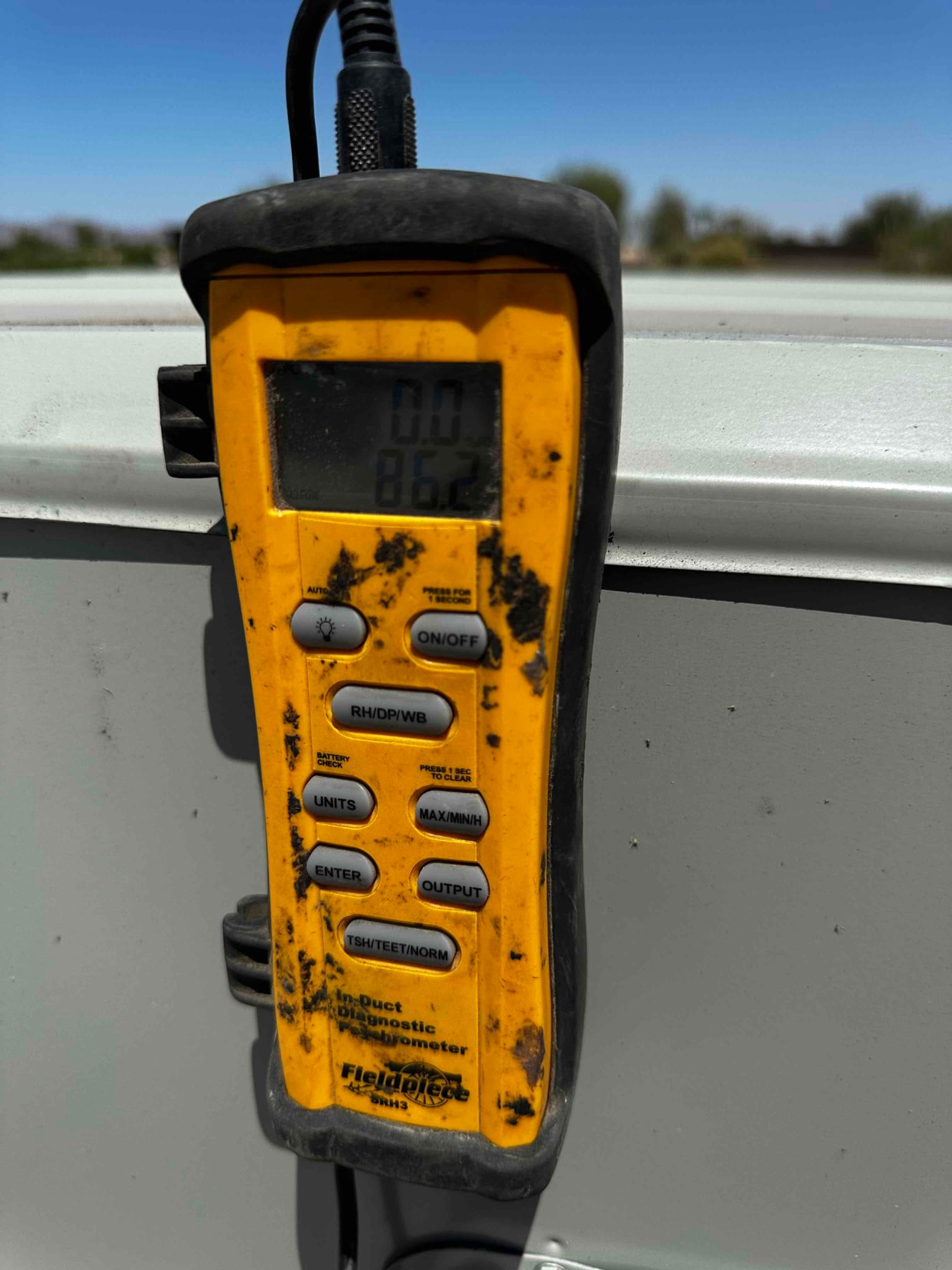 Digital thermometer hygrometer displays 86.2 degrees, documenting an air-side temperature reading during commissioning.