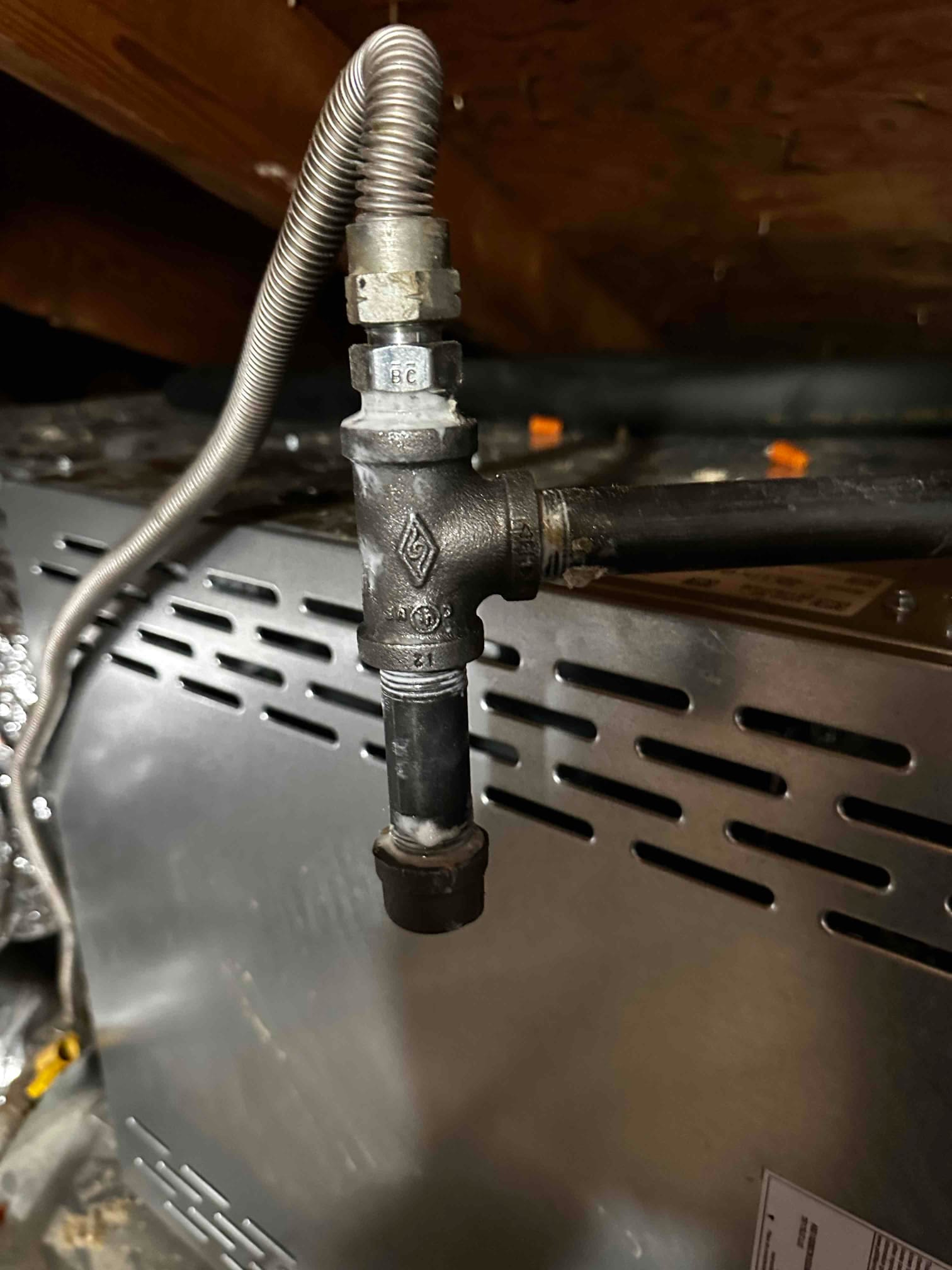 Gas supply connection with sediment trap and flexible connector installed at the furnace in the attic.