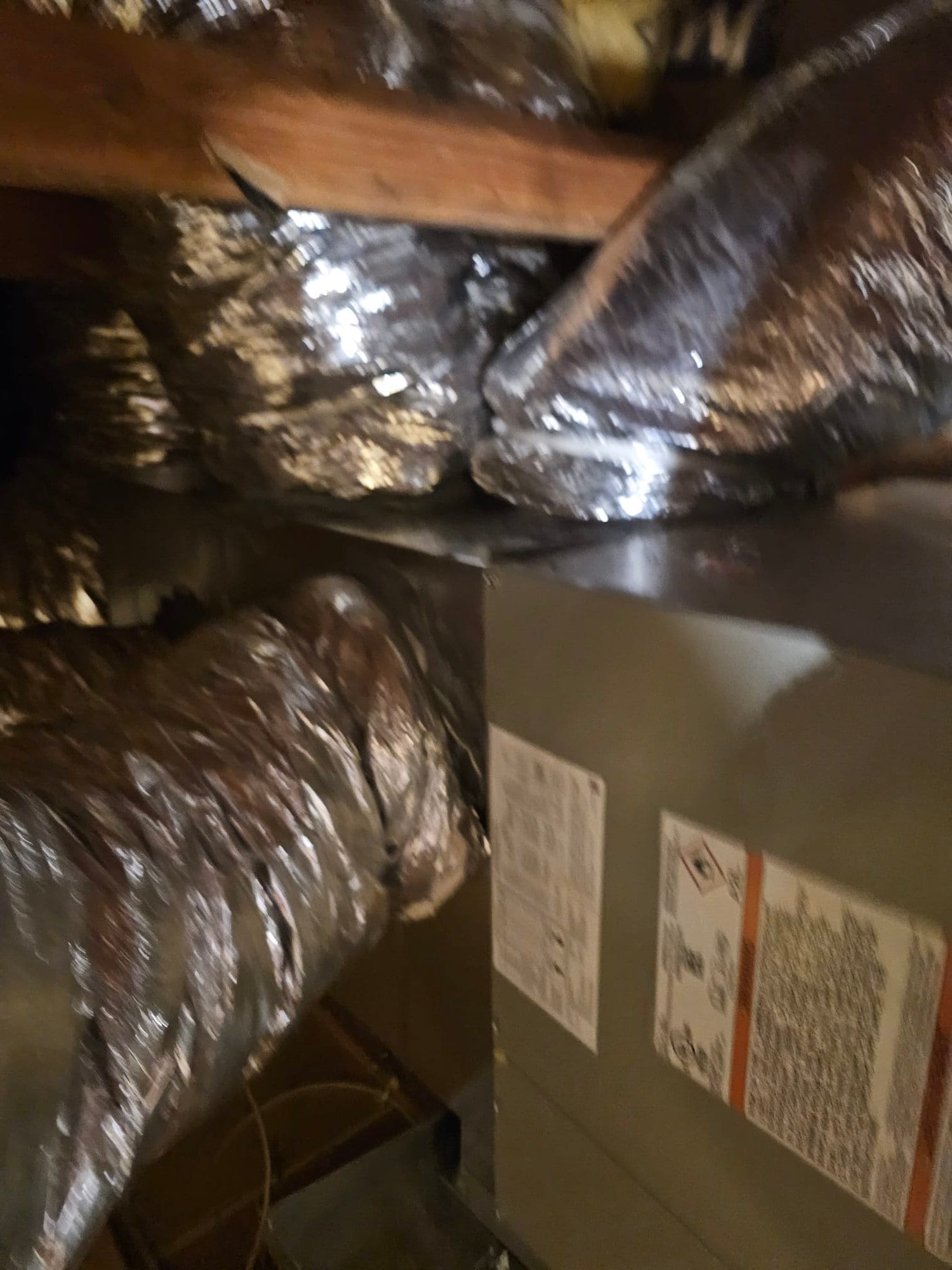 Horizontal attic air handler connected to multiple insulated flexible ducts, showing completed airflow connections and sealed plenum transitions.