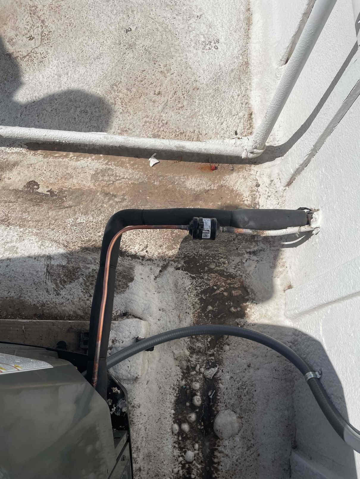 Insulated refrigerant line set and electrical whip connected to the outdoor condenser, with sealed wall penetration and secured routing.