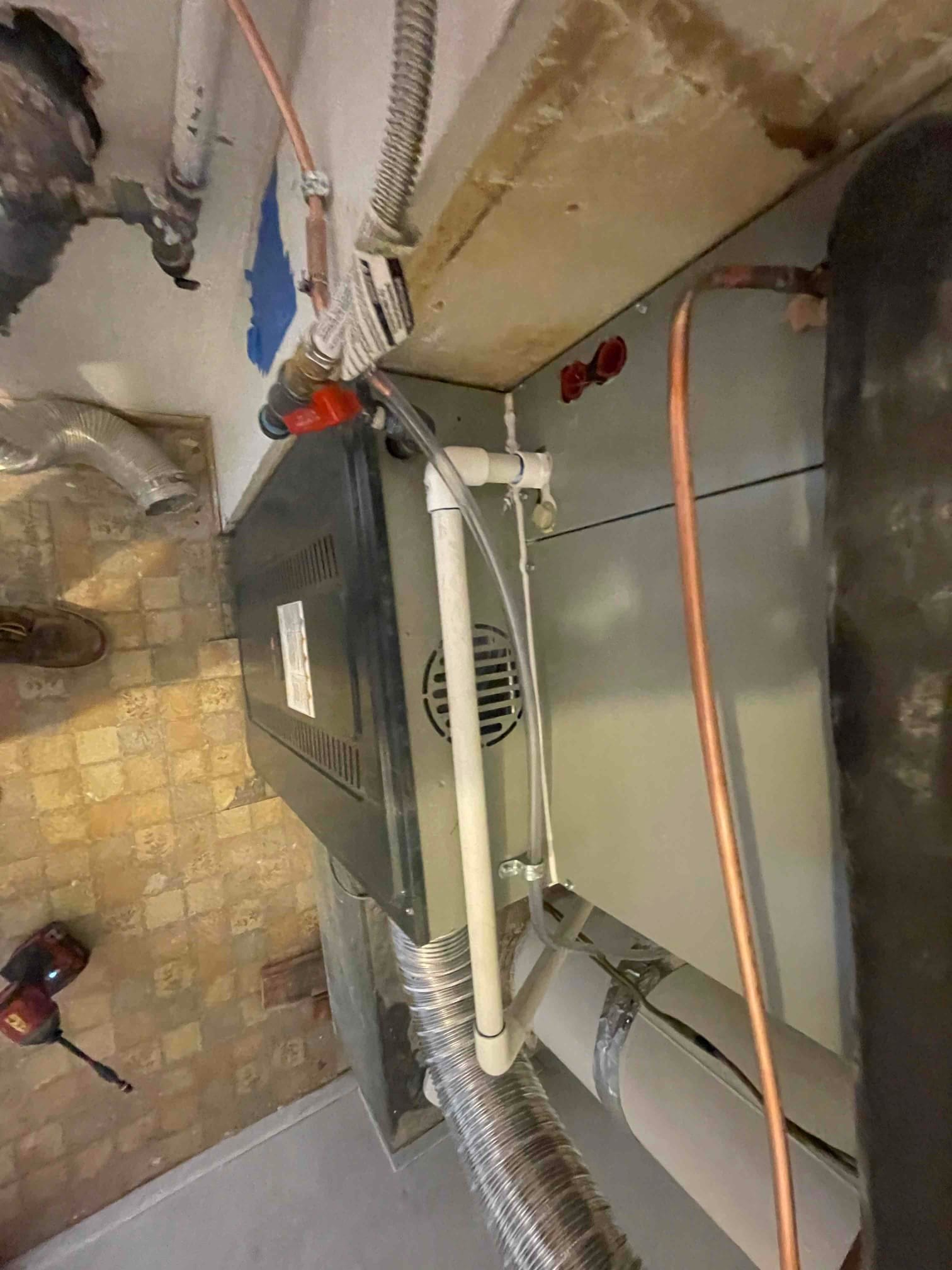 New furnace and coil installed with condensate drain, flexible gas connector, copper refrigerant lines, and venting connected at the mechanical room.