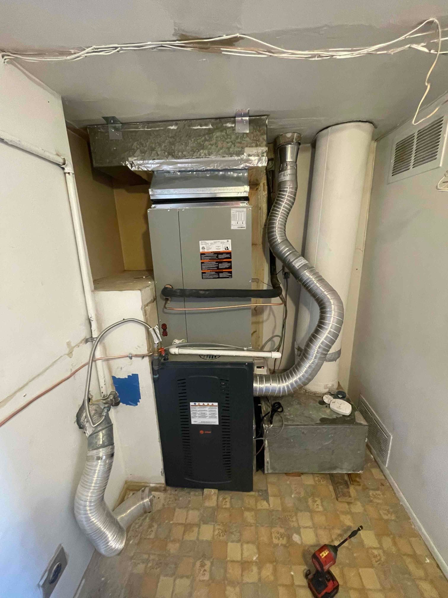 New furnace and evaporator assembly installed with sealed duct connections, venting, condensate drain, and accessible service area in the mechanical room.