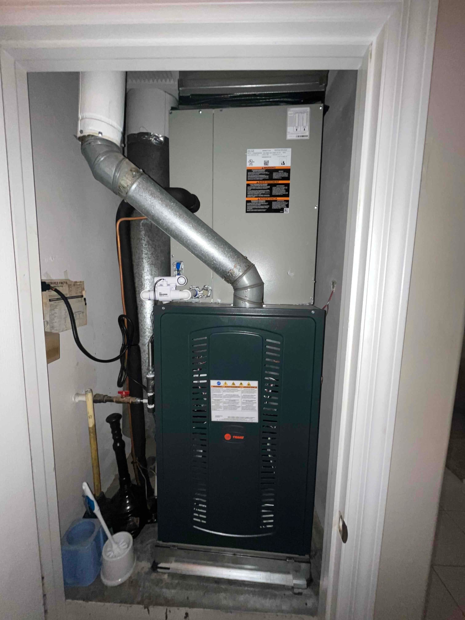 New furnace and evaporator coil installed in a closet, with PVC venting, condensate trap, and gas line connections visible.