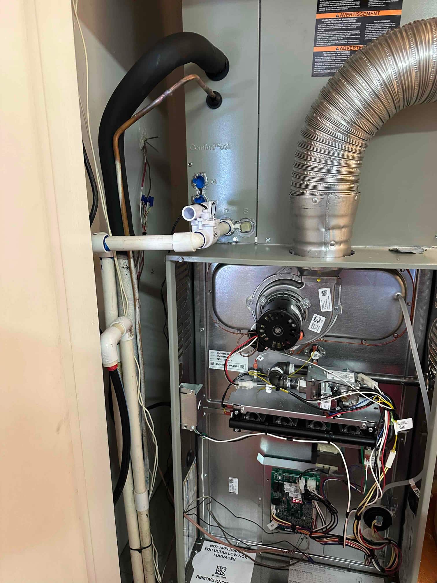 New furnace and evaporator installation with condensate drain, insulated suction line, venting, and open blower compartment showing control board and wiring.