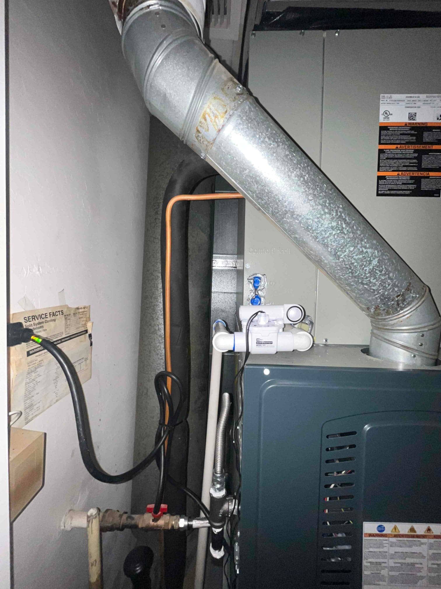 New furnace and evaporator installation with venting, condensate safety switch on the drain, gas line, and electrical connections visible.