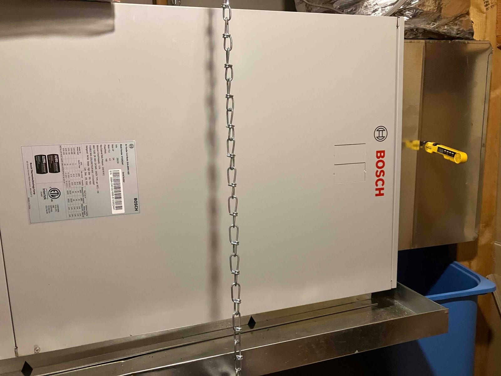 New horizontal air handler set on a hanging platform with drain pan and duct connections visible in the attic space.
