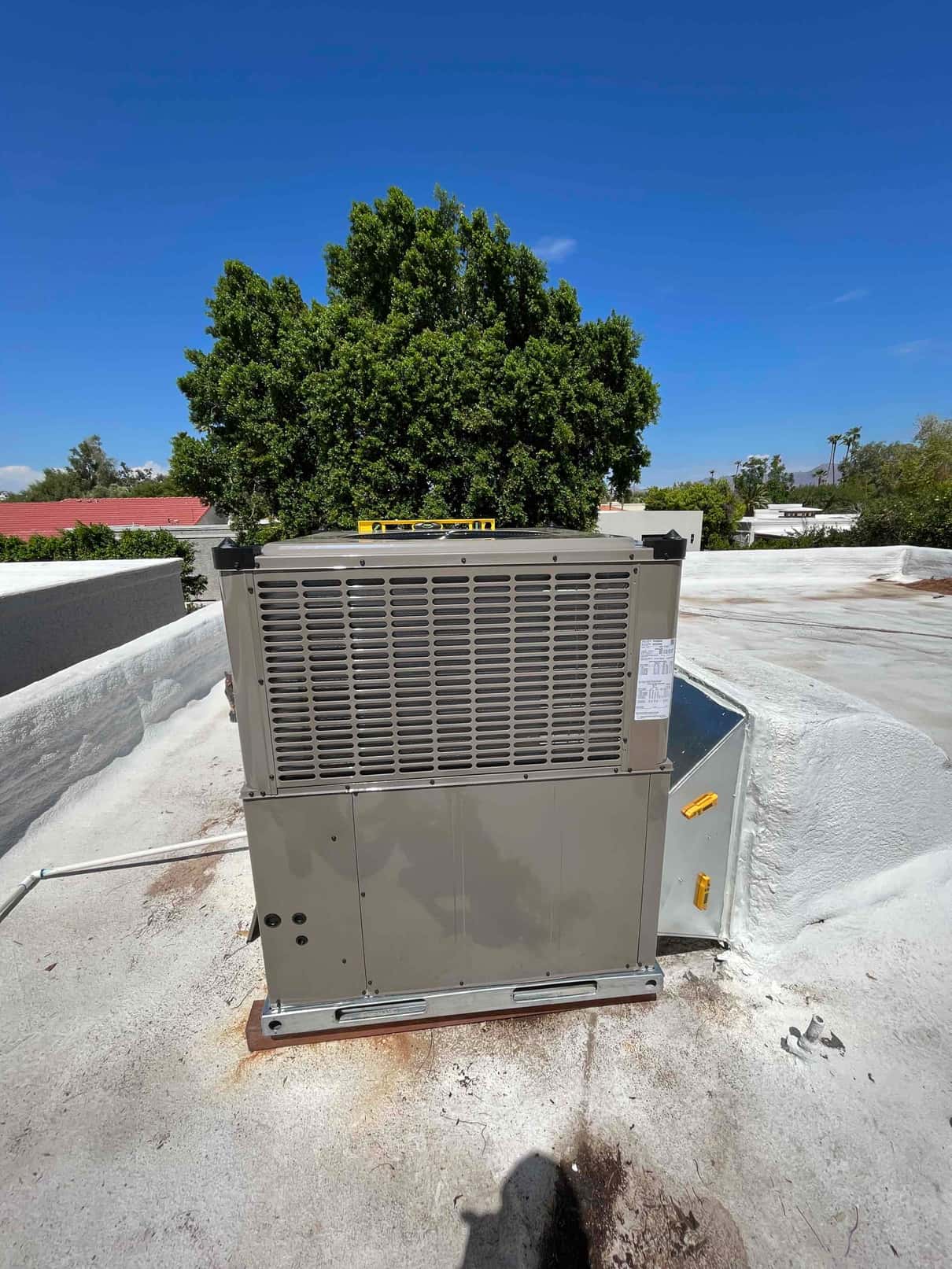 New rooftop package heat pump set on curb with level on top and sealed duct transition connected.