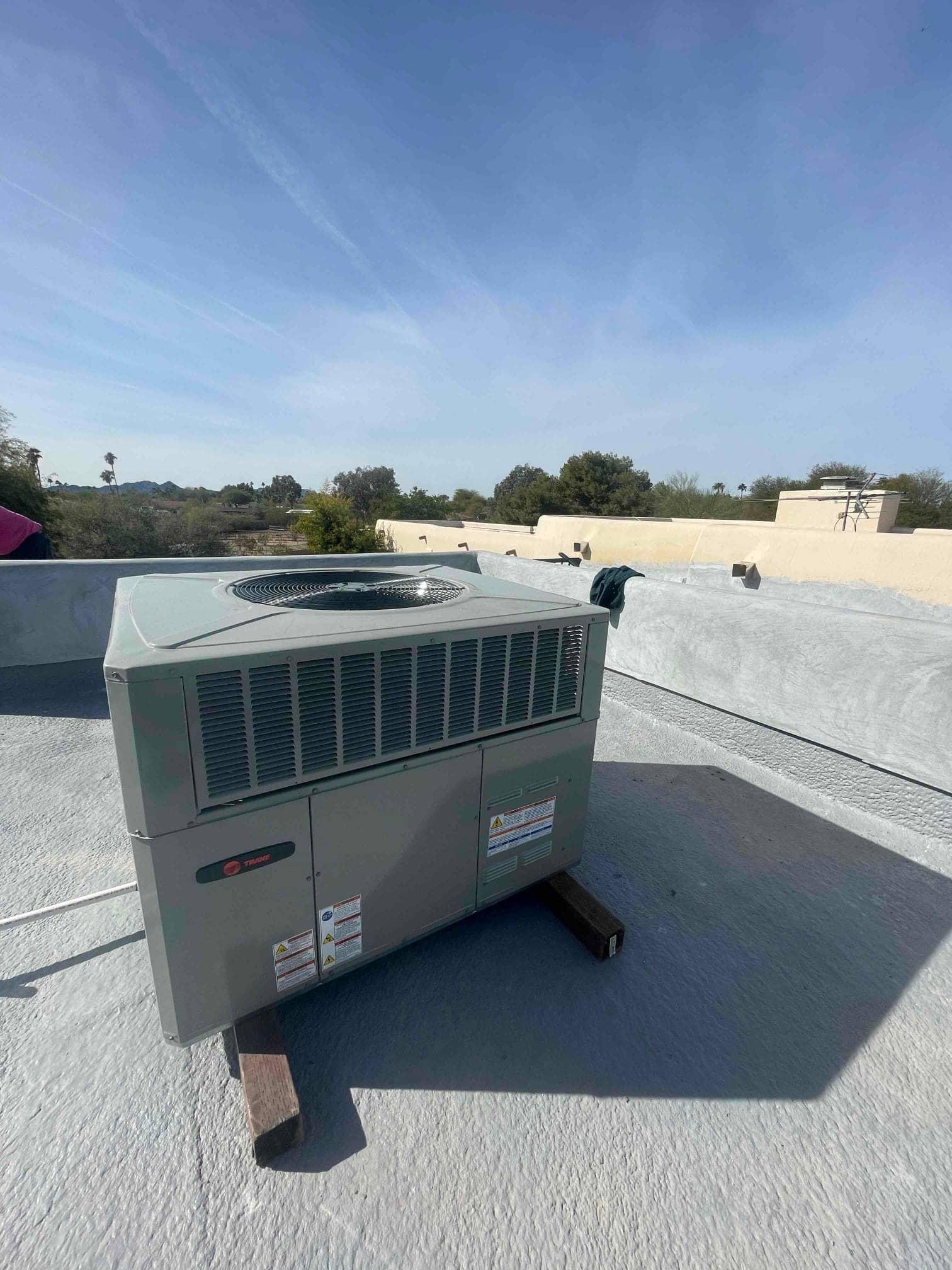 New rooftop packaged HVAC unit set on riser blocks with secured panels and rooftop penetration sealed.