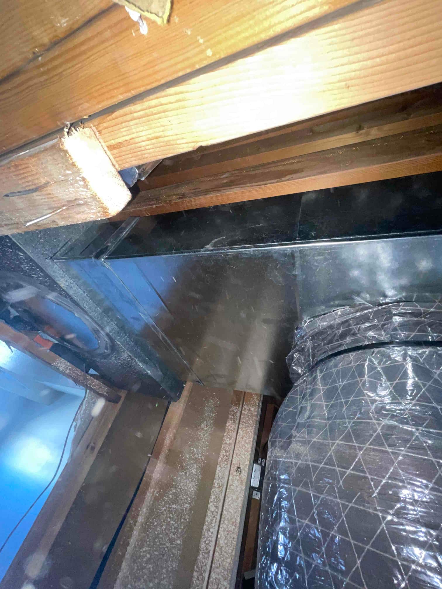 New sheet-metal duct transition and insulated flexible duct installed in attic framing, with sealed connections and proper support.