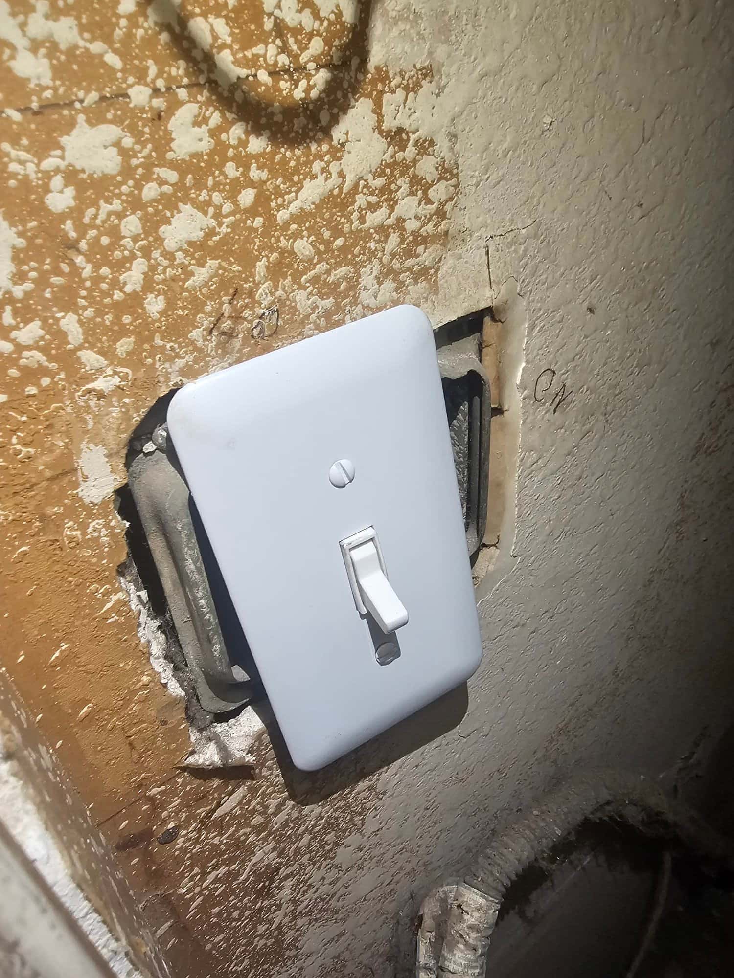 New wall-mounted control switch installed in a textured wall opening, providing on-off control for the evaporative cooler system.