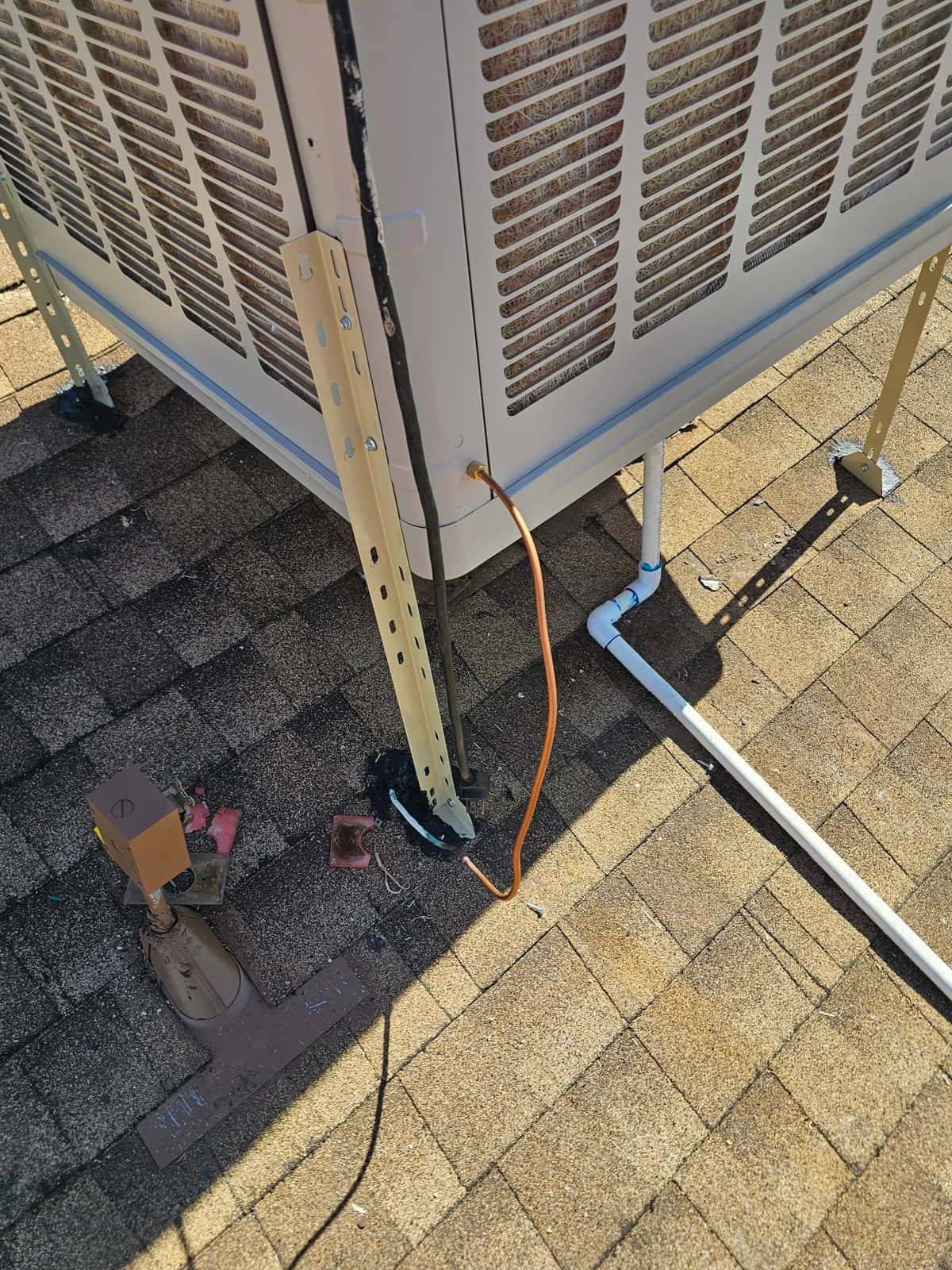 Outdoor condenser mounted on roof stands with insulated line set, drain piping, and service ports accessible for commissioning.