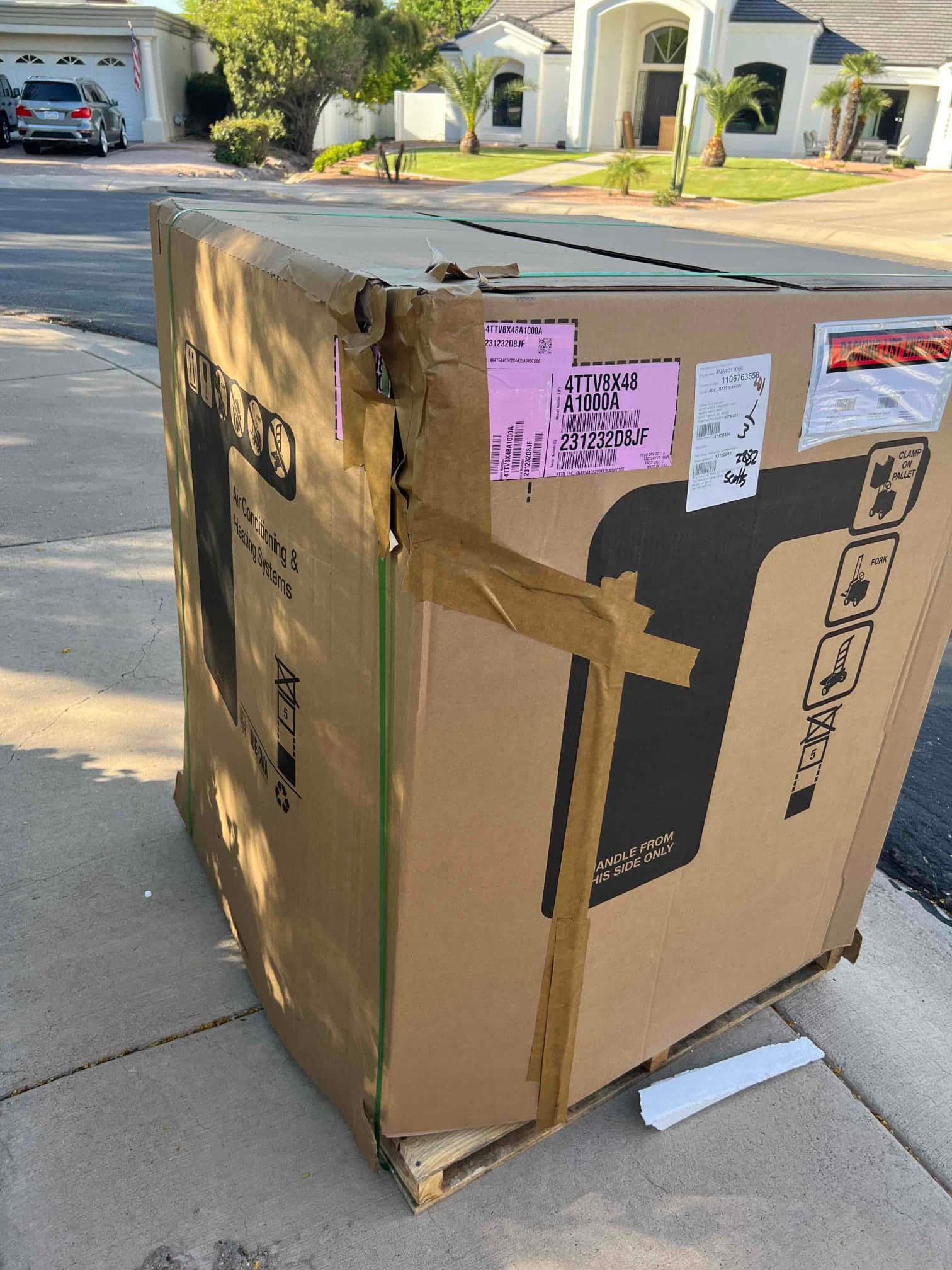 Packaged HVAC equipment sits on a pallet at the installation site, ready for unpacking and placement.