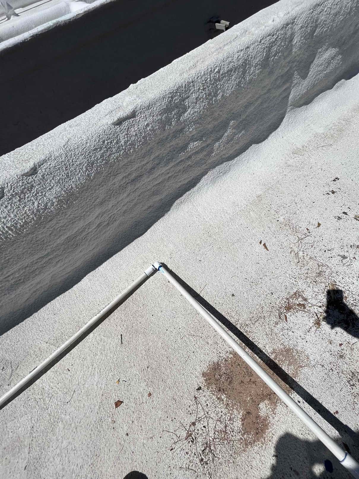 PVC condensate drain line routed across the rooftop with glued elbow fittings and clean, sealed connections.