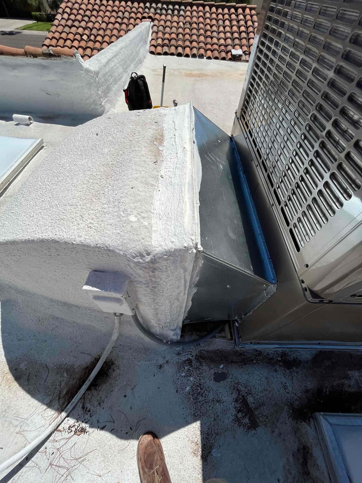 Rooftop package unit tied into a newly fabricated supply plenum with sealed transitions and weatherproofed roof penetration.