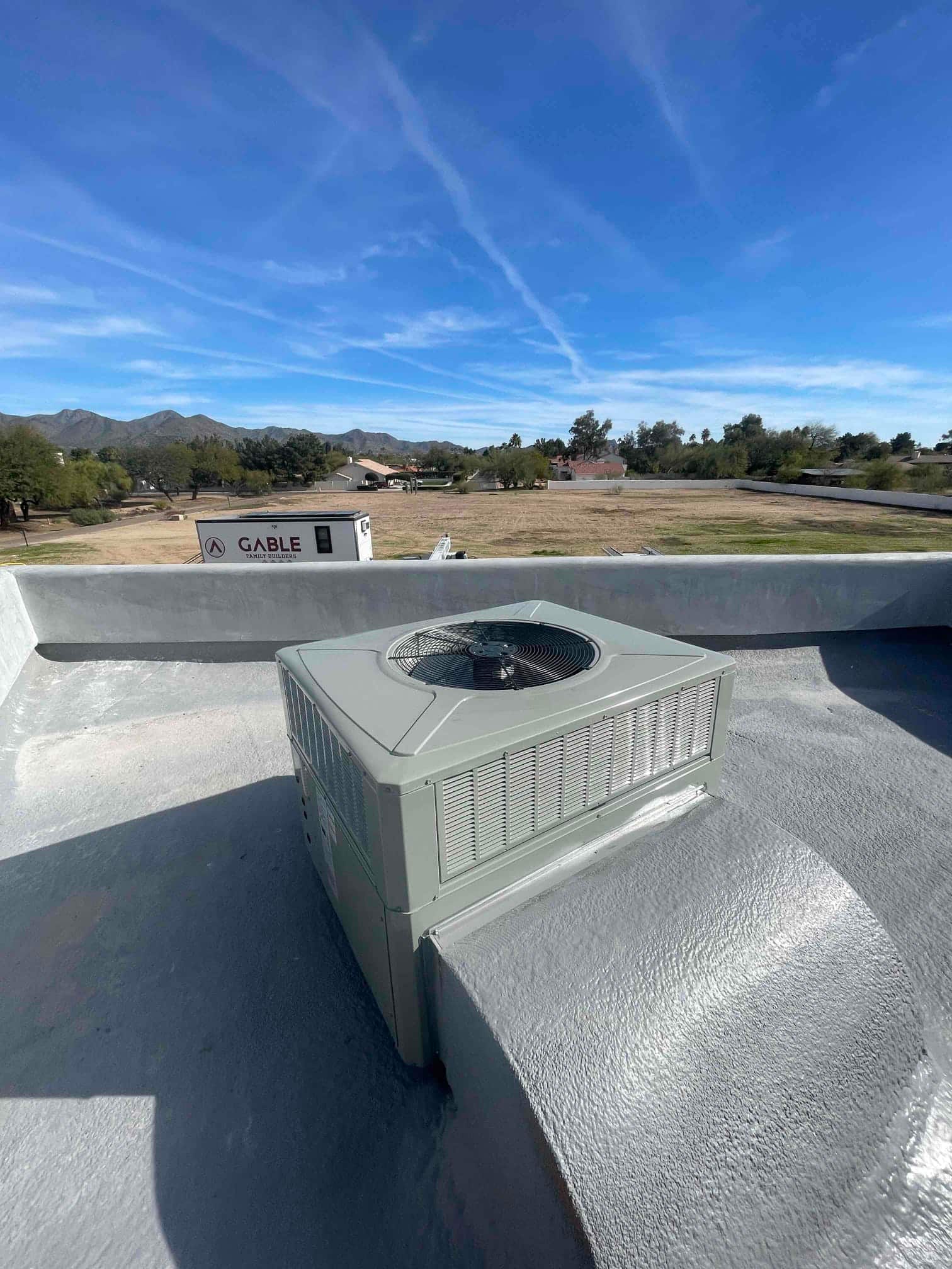 Rooftop packaged HVAC unit newly installed on a coated roof, connected to a sealed supply/return curb transition.