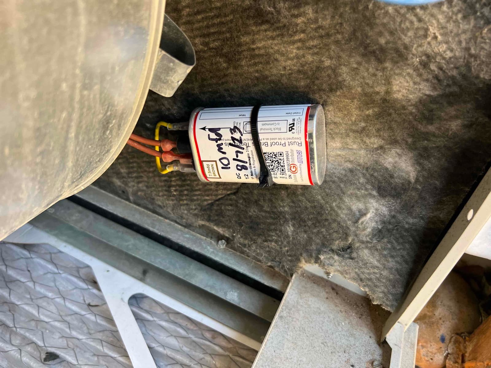 Start capacitor zip-tied inside the cabinet with two brown wires connected to its terminals.