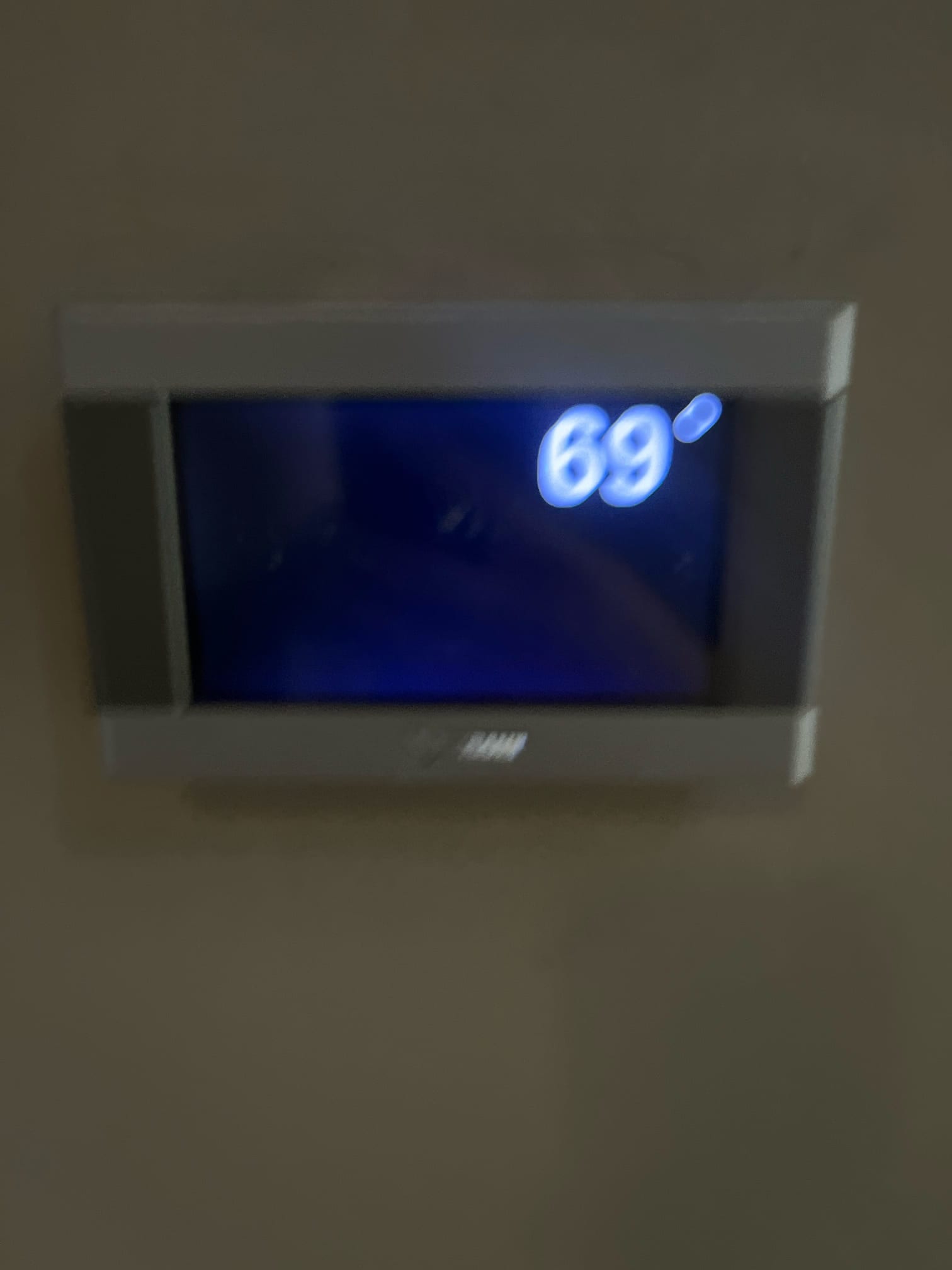 Thermostat display shows room temperature at 69 °F during air conditioning service.