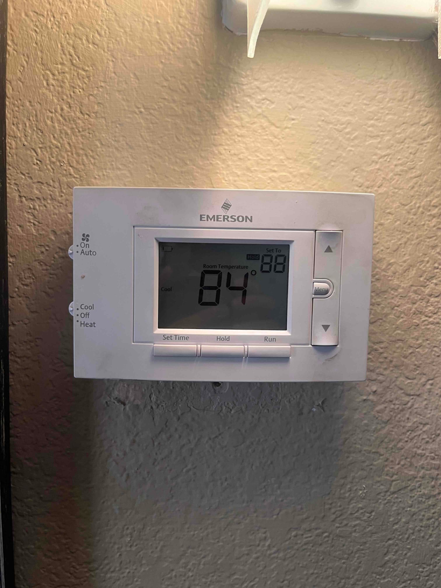 Thermostat display shows room temperature at 84 °F with cooling mode selected and system running.