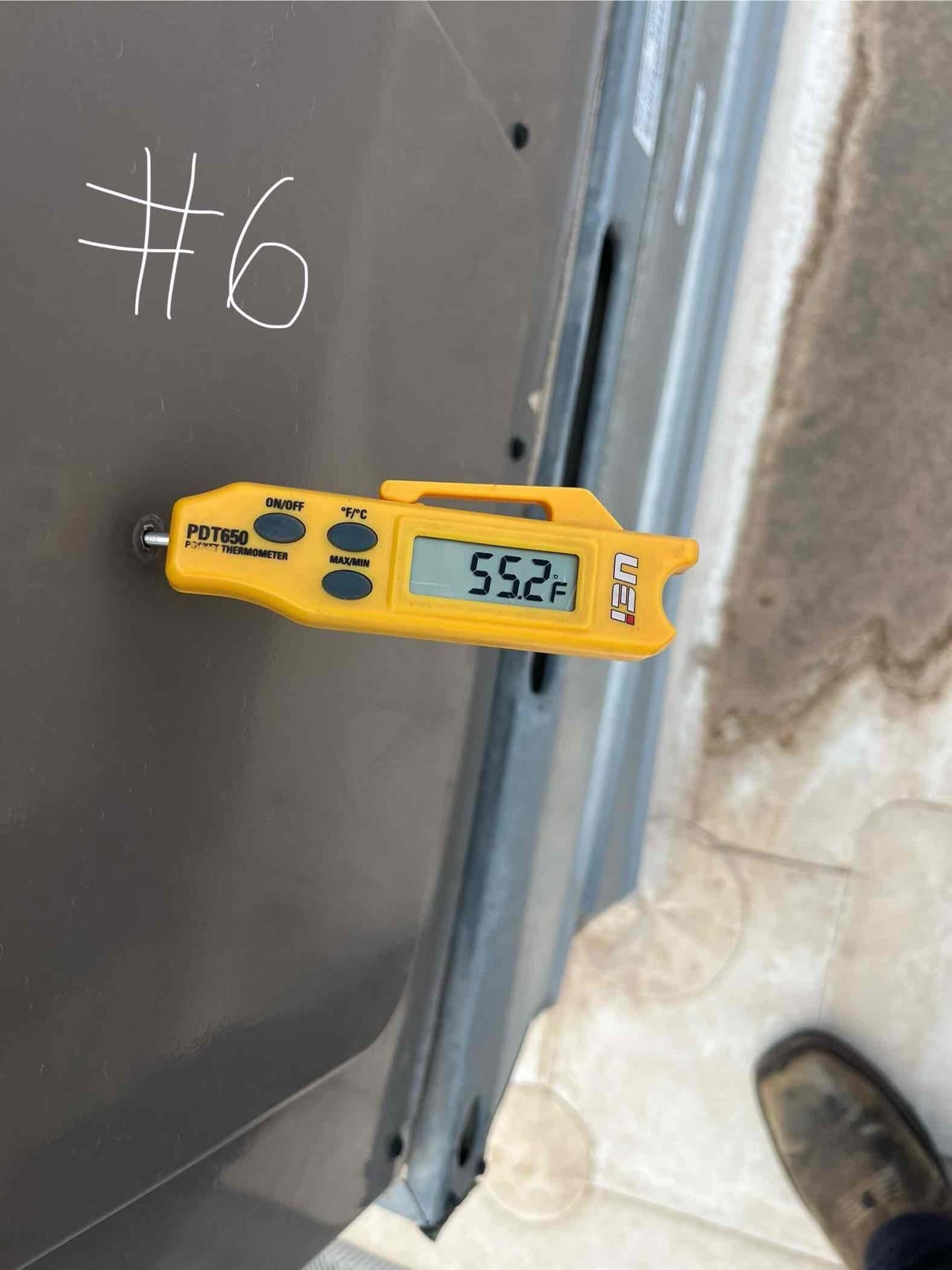 Digital thermometer measures 55.2 °F on the metal equipment panel near the repair area.
