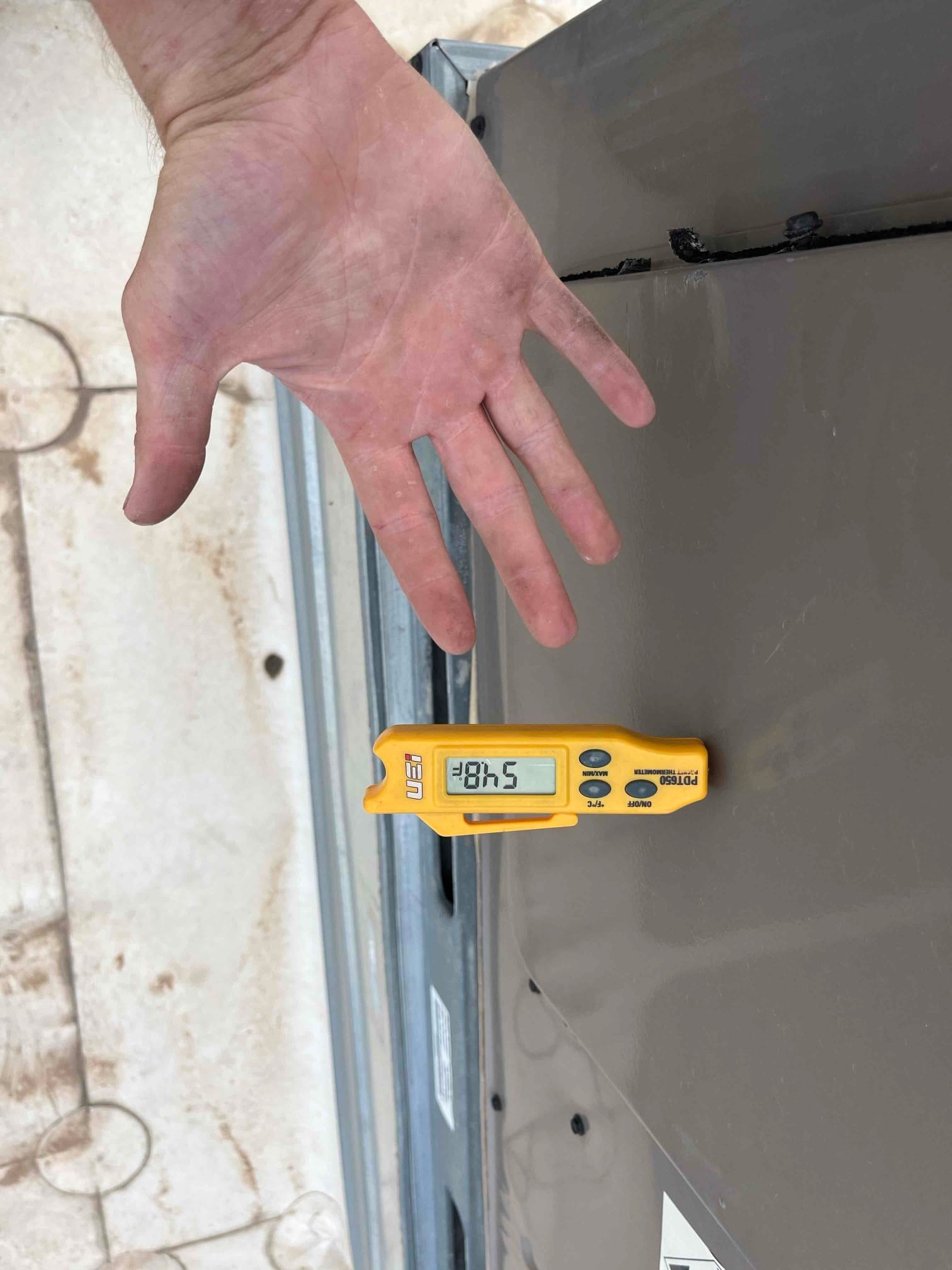 Digital thermometer shows 48.5 °F on the metal equipment panel next to the installed component.