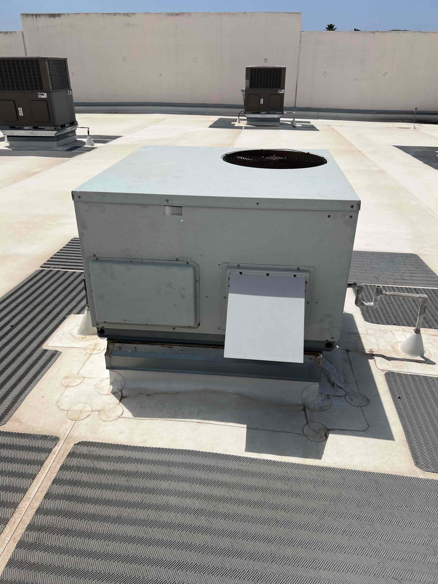 Rooftop package HVAC unit on curb mount, showing exterior access panels and top-mounted condenser fan opening.