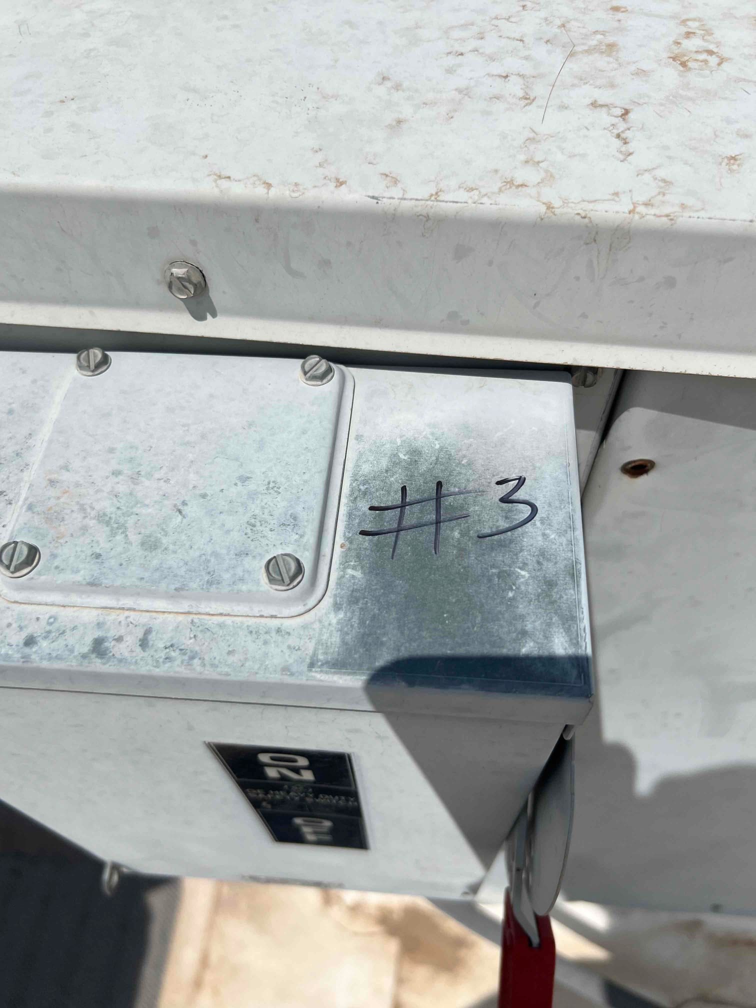 Surface-mount electrical enclosure labeled “#3” installed on exterior HVAC equipment with secured cover and visible disconnect handle.