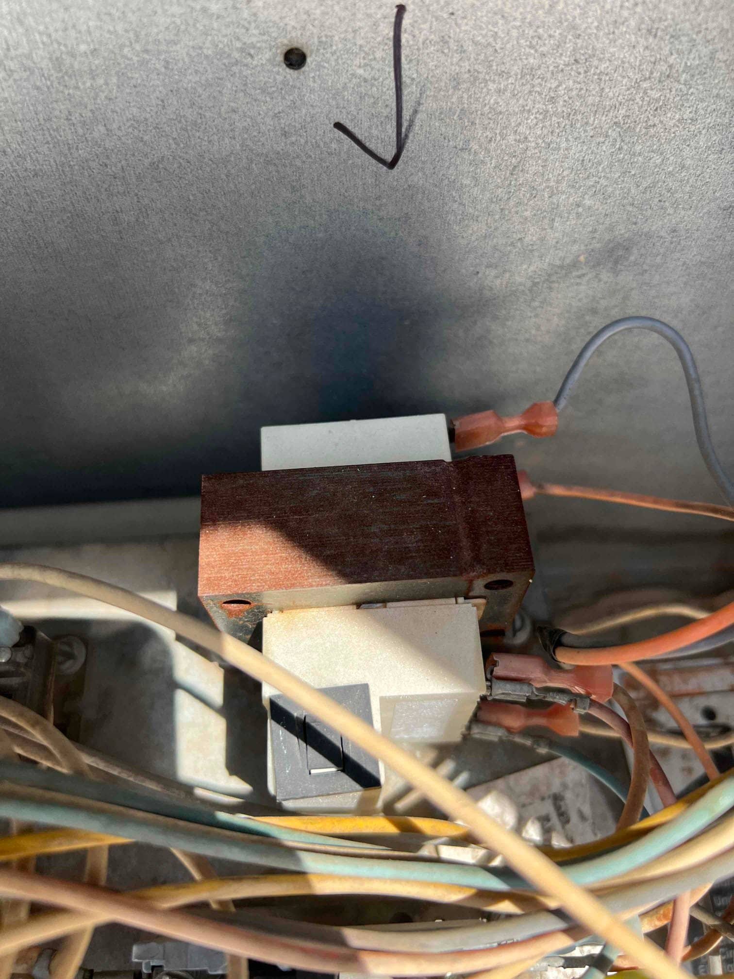 Surface-mount transformer installed inside the unit with connected low-voltage leads and secured mounting bracket.