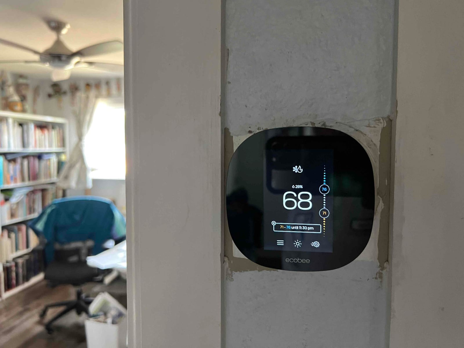 Wall-mounted smart thermostat displays a cooling setpoint of 68 degrees after installation in a finished living space.