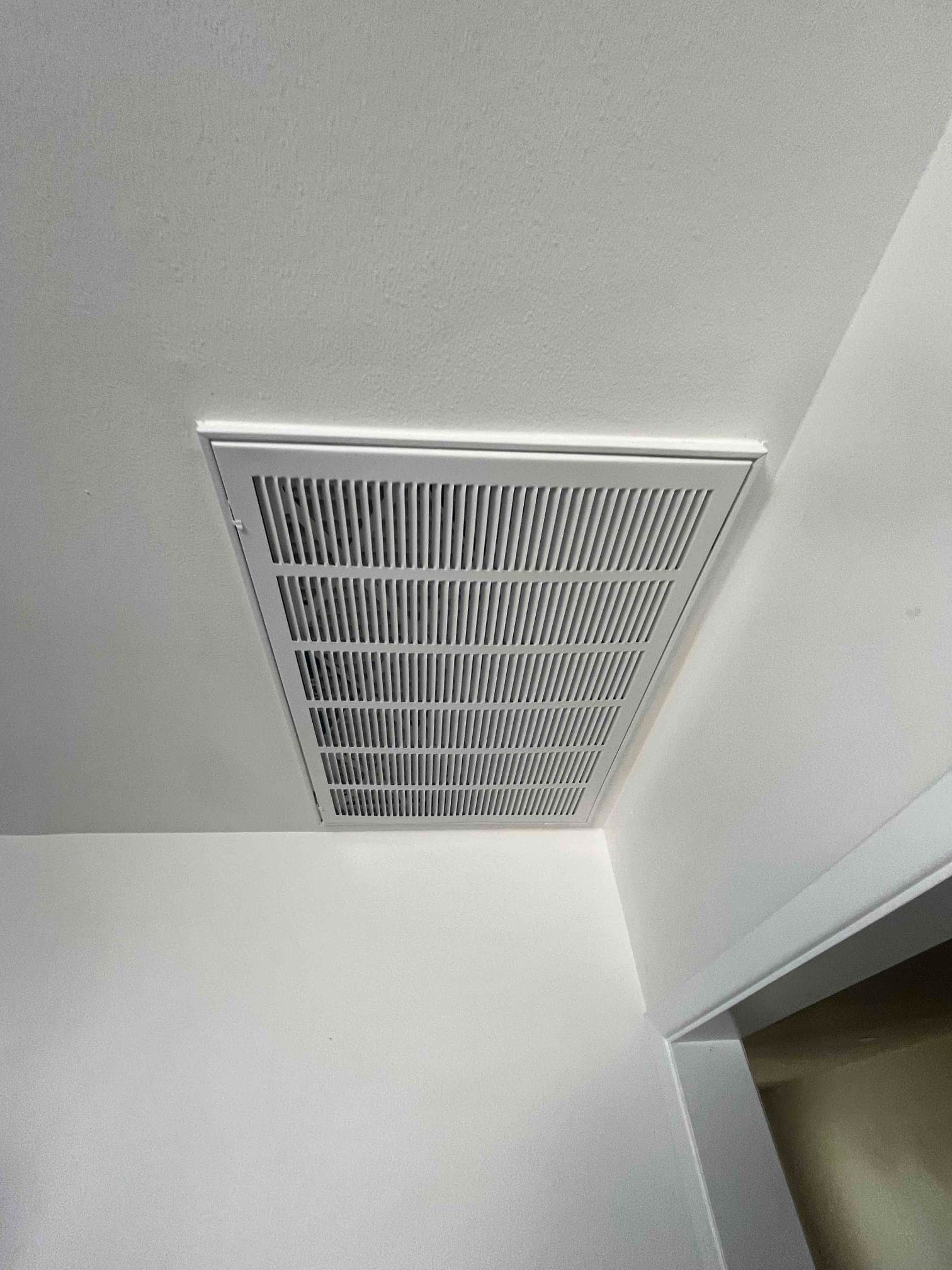 Ceiling-mounted return air grille installed flush with surrounding drywall, showing straight, even fins and clean finished edges.