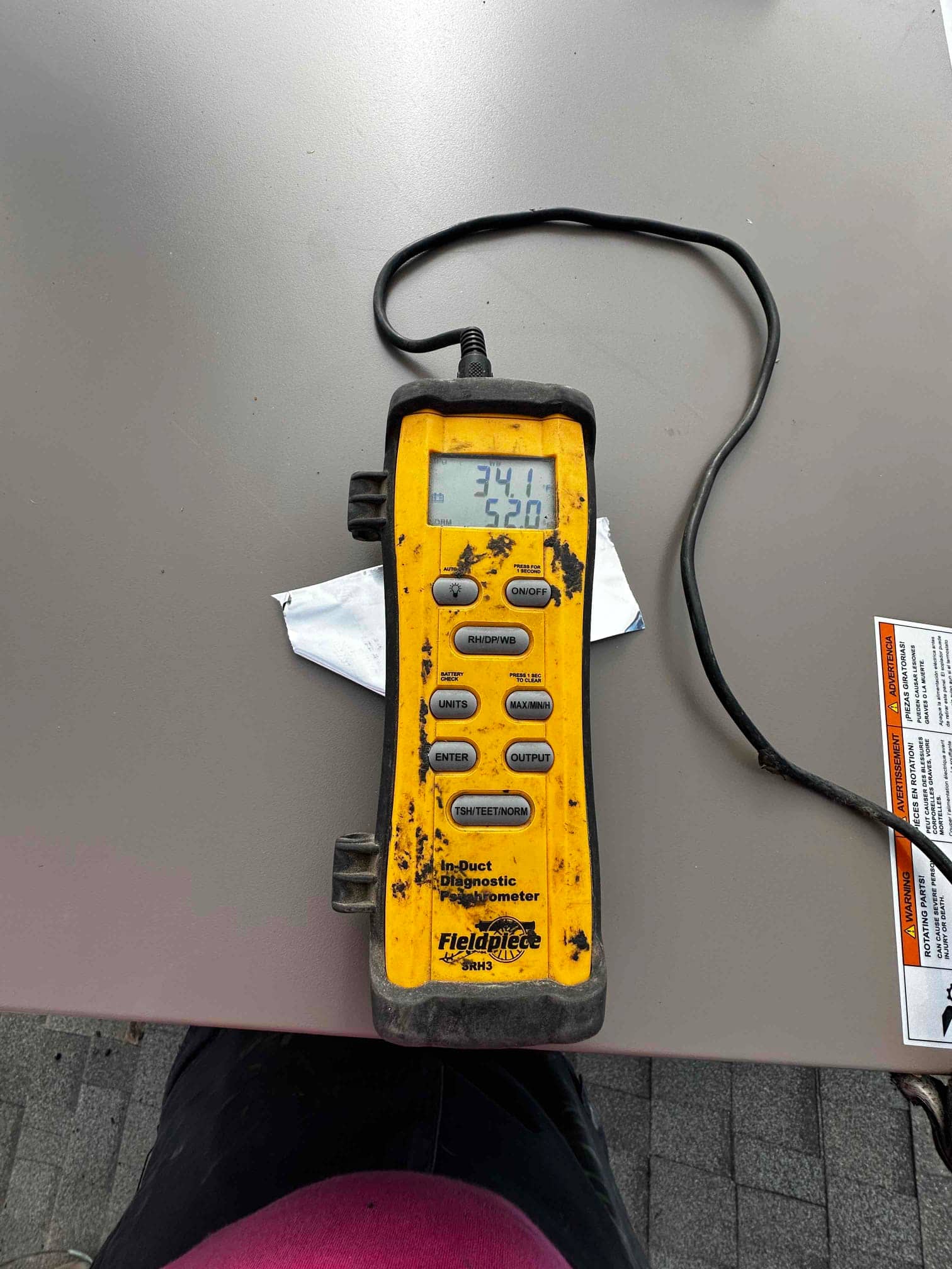 Digital in-duct thermometer displays supply air temperature of 52.0°F during cooling performance verification on the new installation.