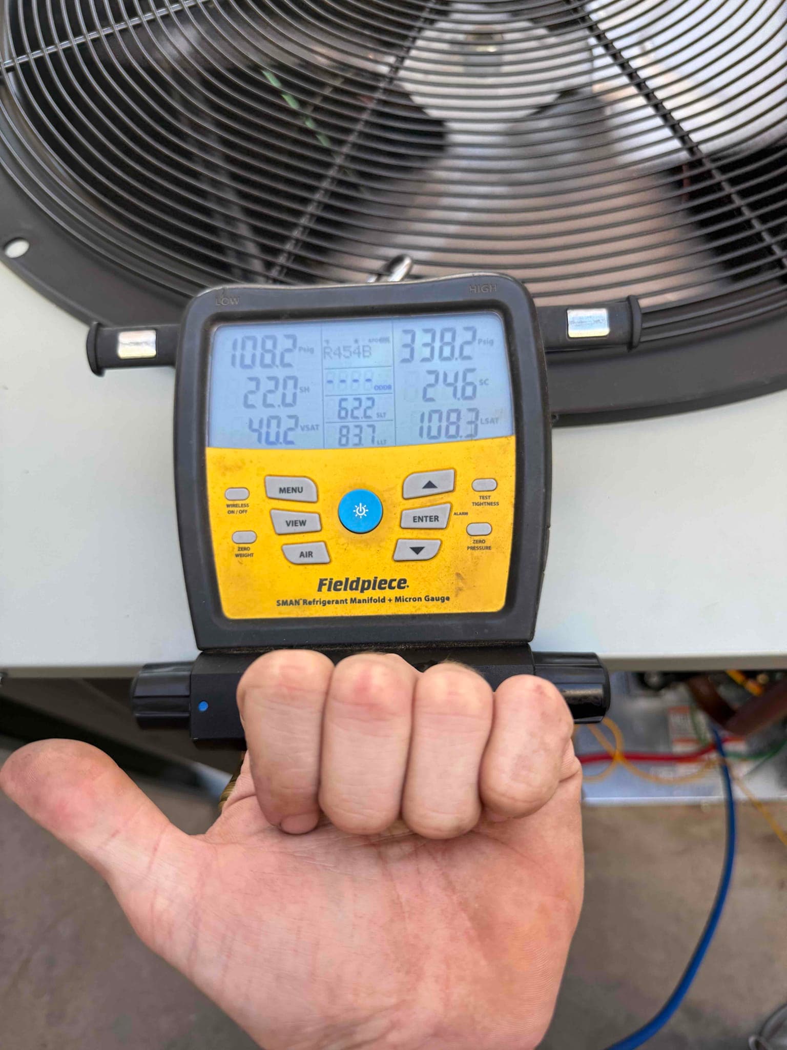 Digital manifold connected at the condenser shows operating pressures with R-454B selected during commissioning of the new heat pump system.